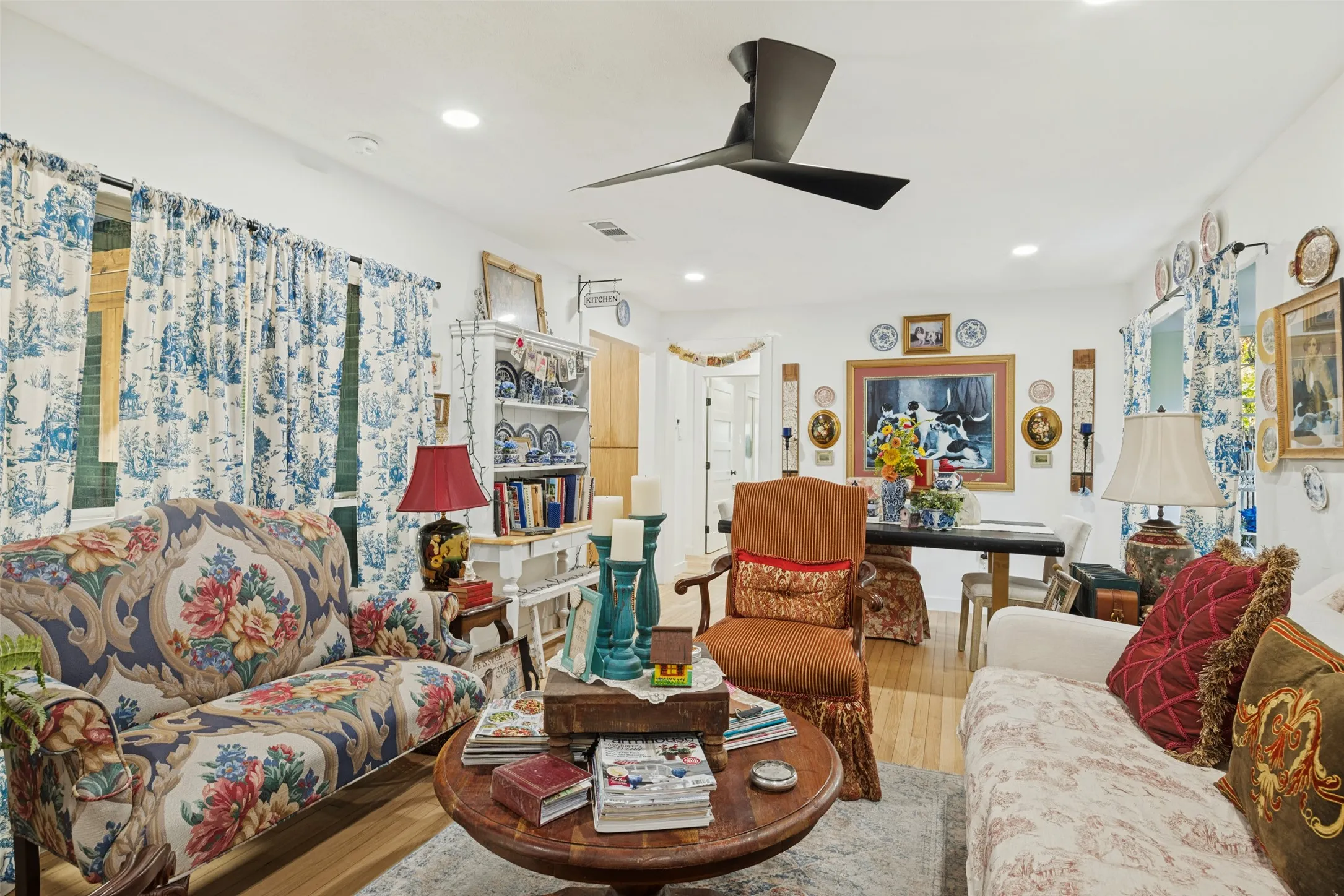 Recessed lighting, wood-finish flooring, a contemporary ceiling fan, and a built-in shelving unit