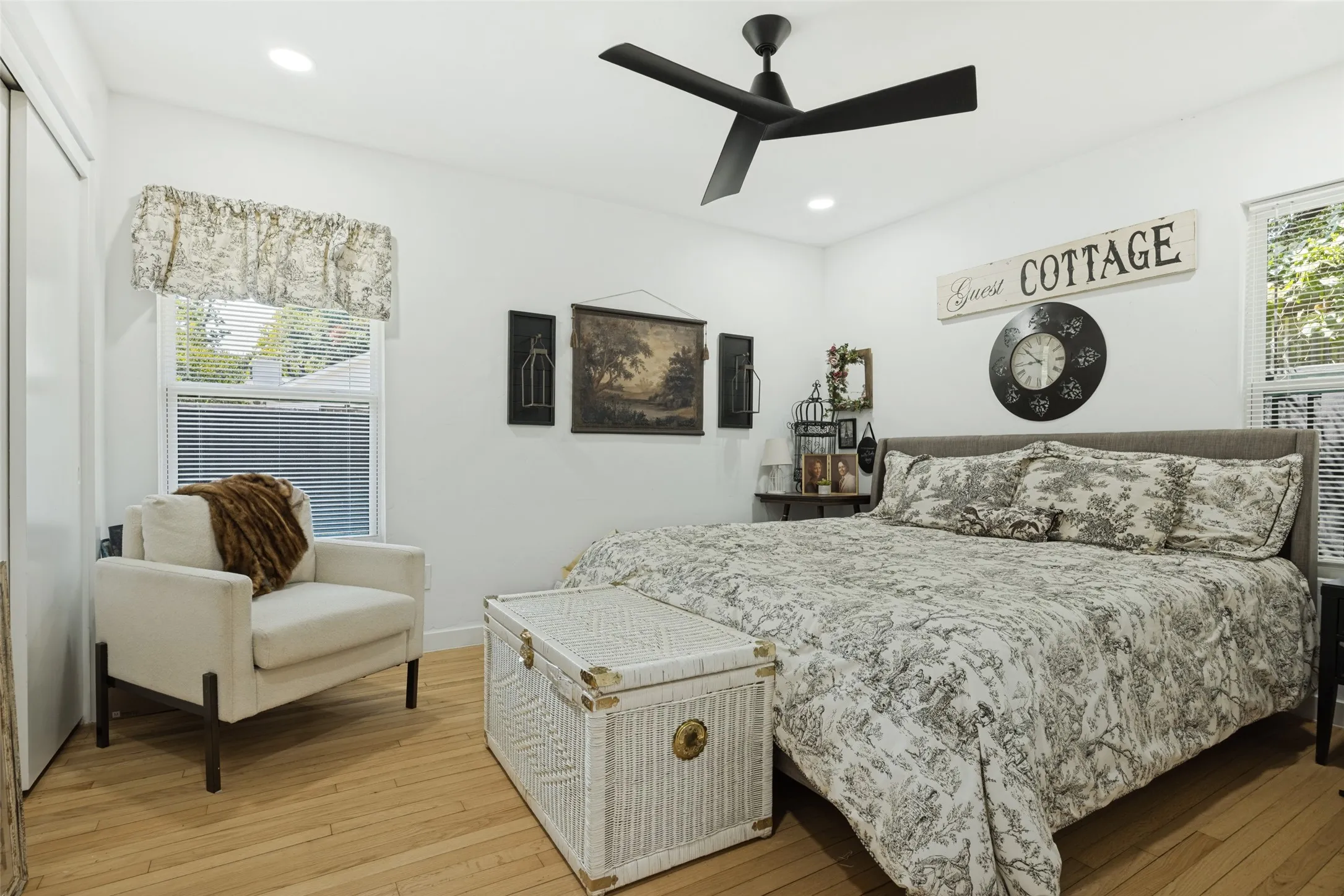 Recessed lighting, light wood-finish flooring, white walls, and a contemporary black ceiling fan