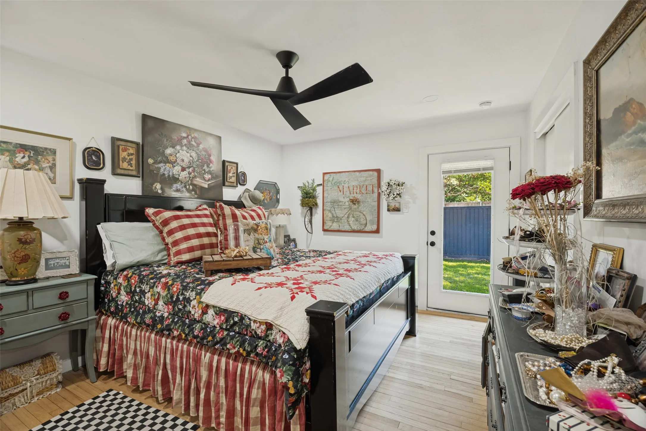 Light wood-finish flooring, ceiling fan, and a glass-paneled door leading to an outdoor space