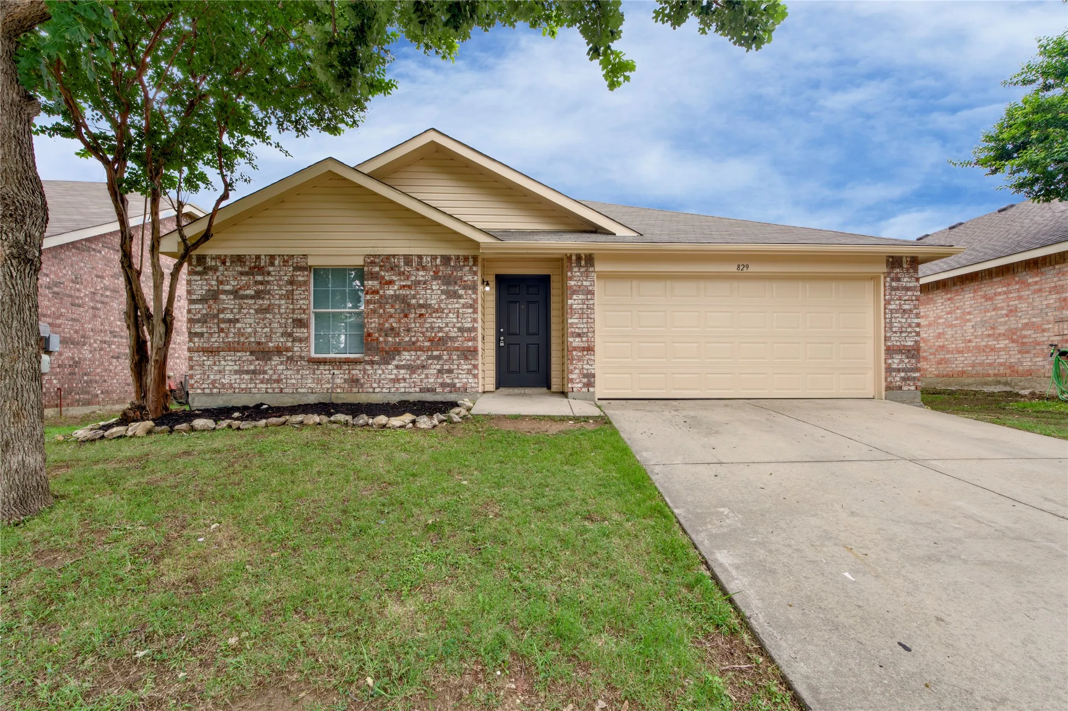 Brick and siding exterior with a dark front door