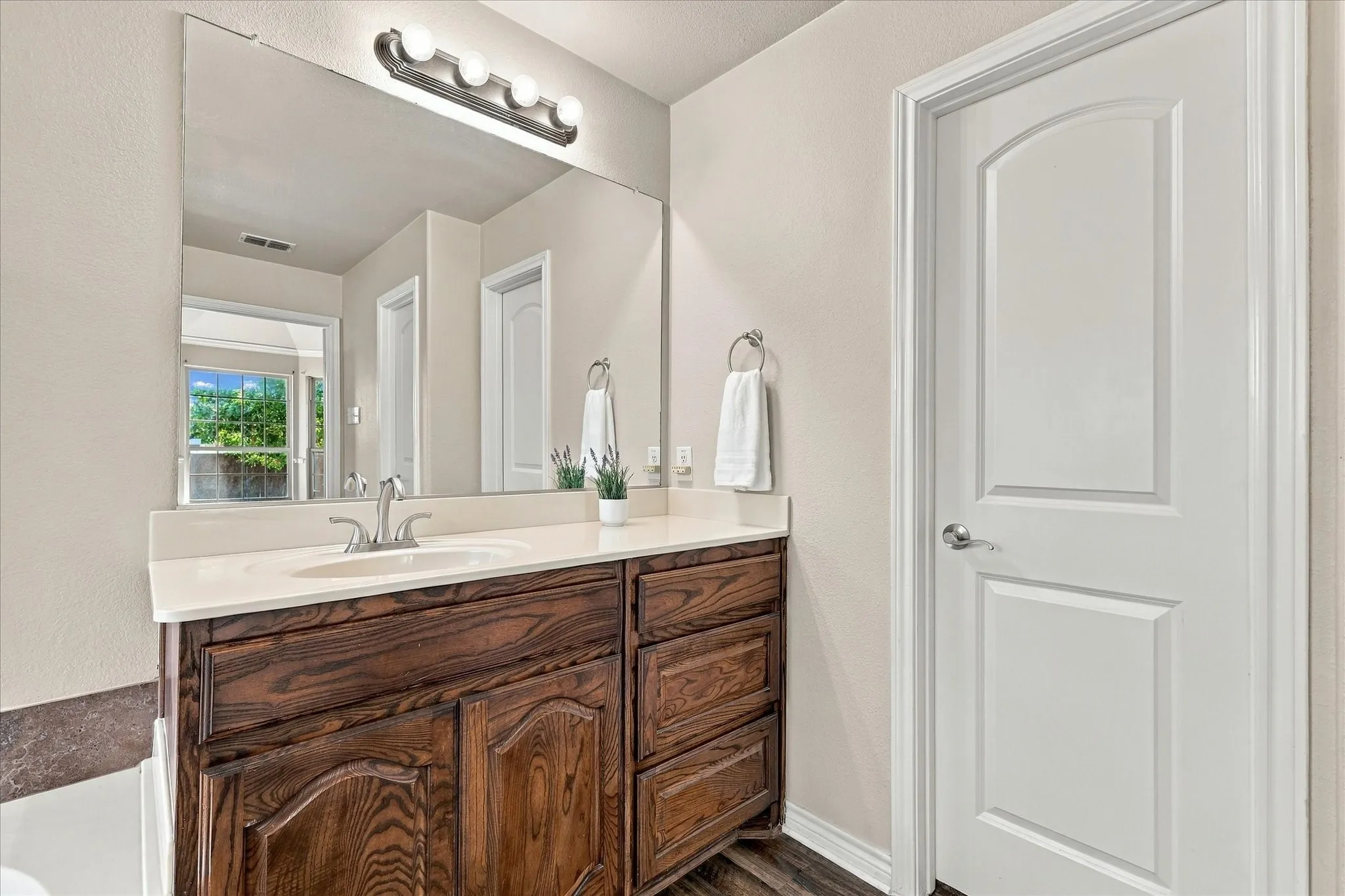 Dark wood-finish vanity with a light-toned countertop and an integrated sink