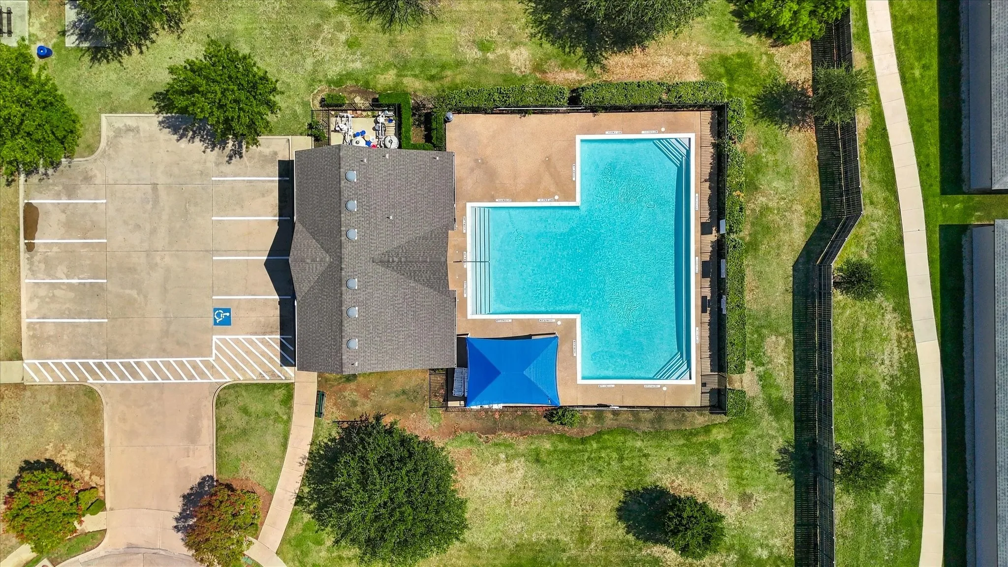 Recreational swimming pool with perimeter fencing and a shaded lounge area