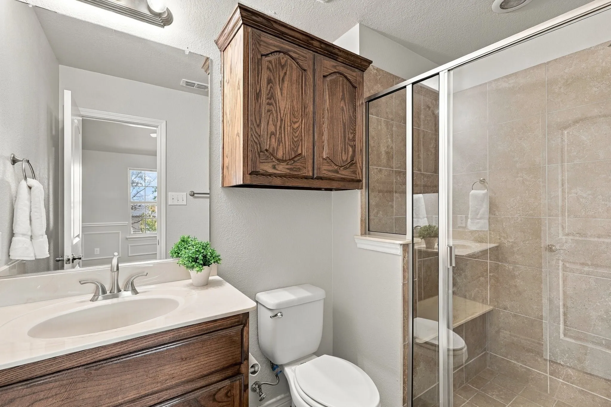 Wood-finish vanity with an integrated sink and light-colored countertop