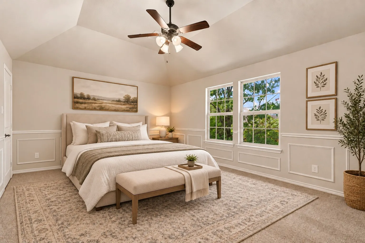 Vaulted ceiling with a ceiling fan, dual windows, wainscoting, and carpeted flooring