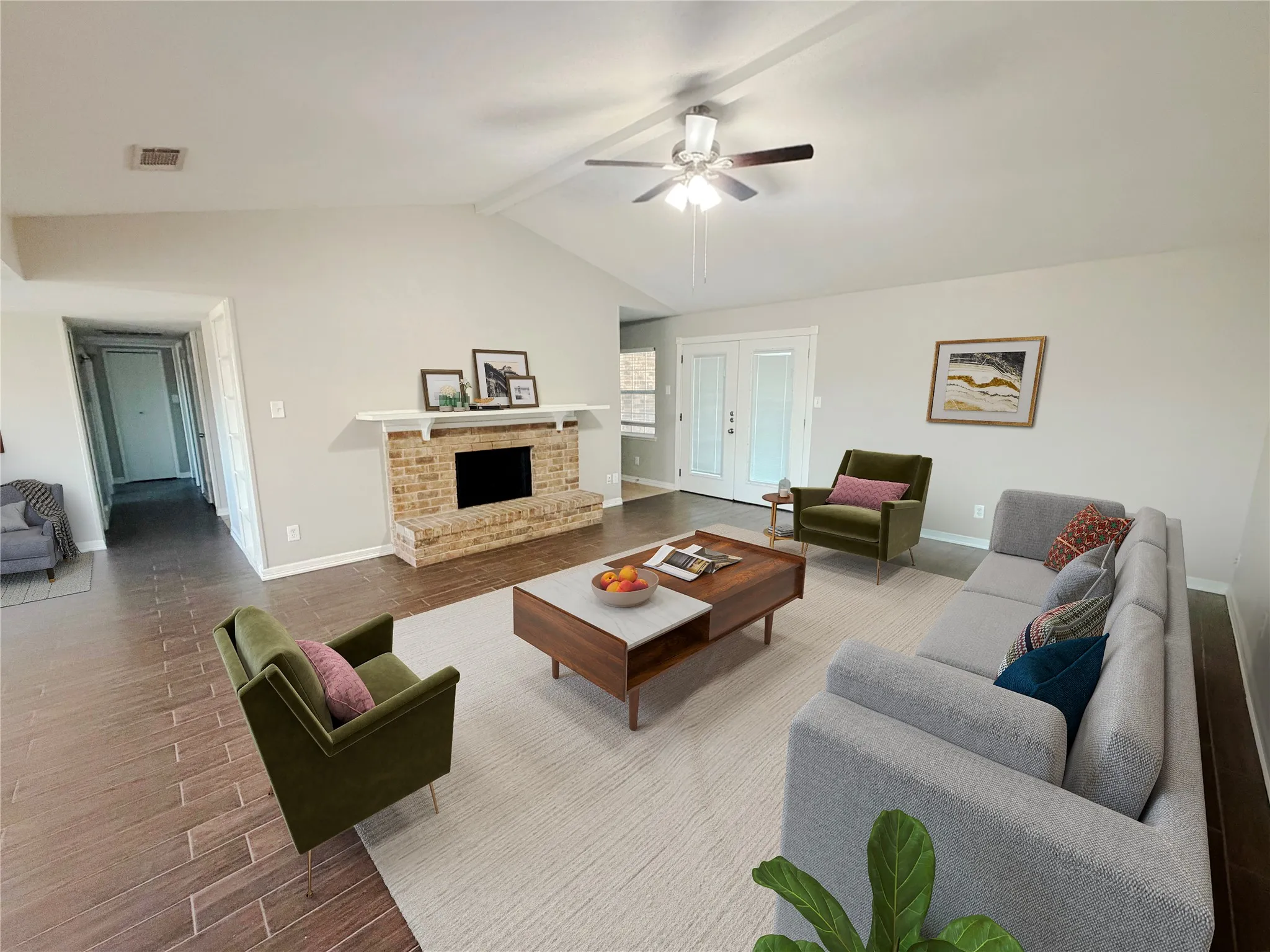 Vaulted ceiling living area featuring a brick fireplace with a white mantel, wood-finish flooring, and white double doors