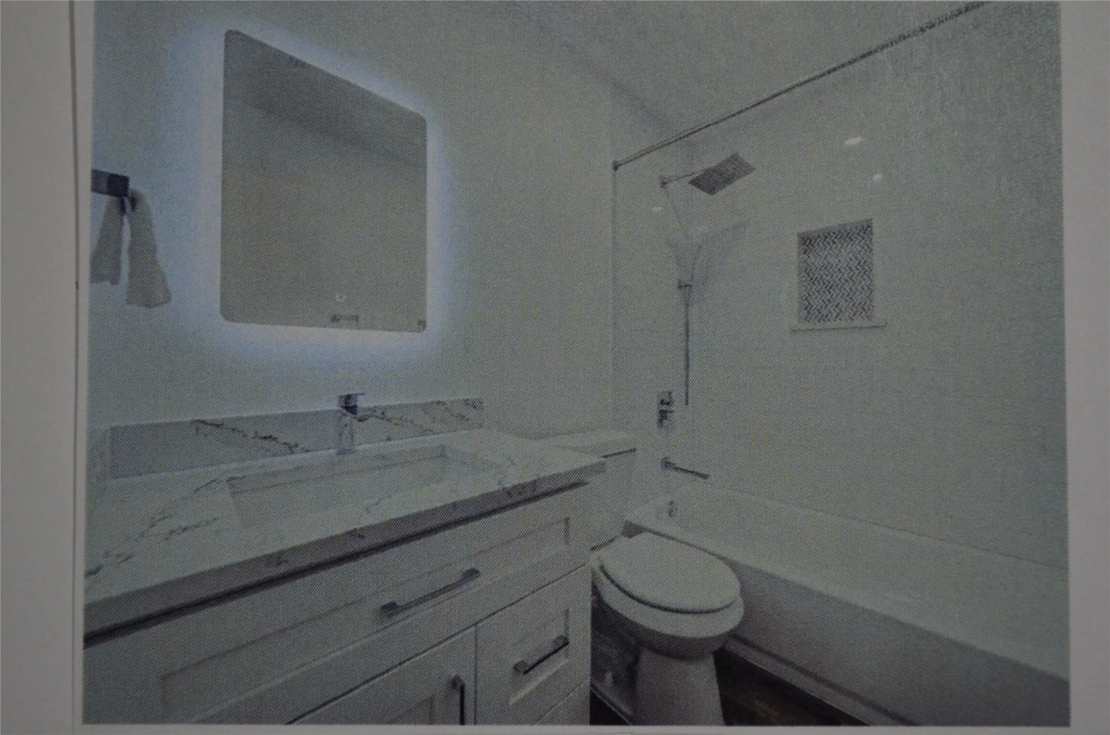 Bathroom featuring a vanity with an integrated sink, a back-lit mirror, a wall-mounted faucet, a shower/tub combination, and a built-in shower niche