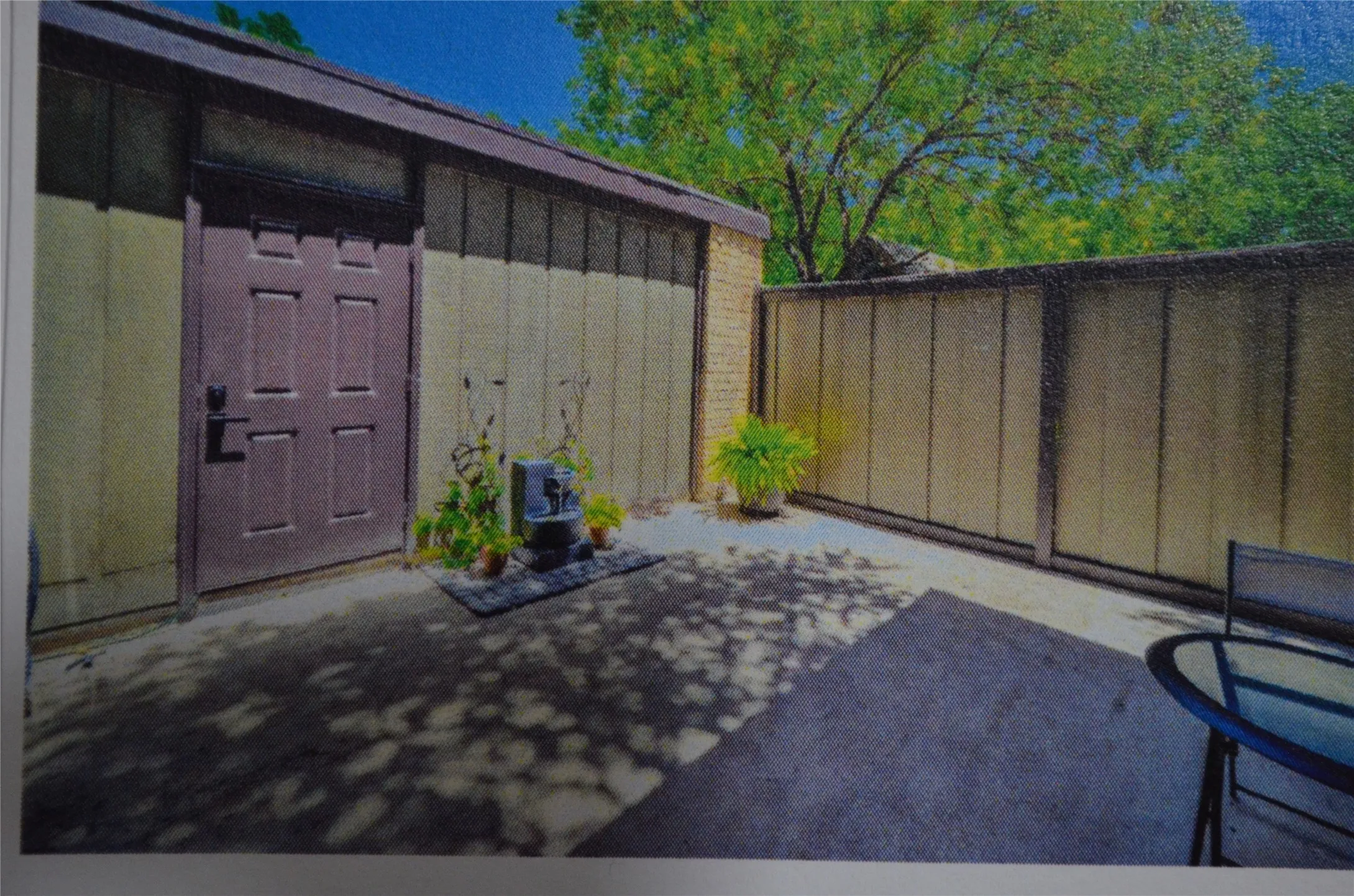 Private exterior courtyard with a solid panel fence, panel siding, and a solid entry door