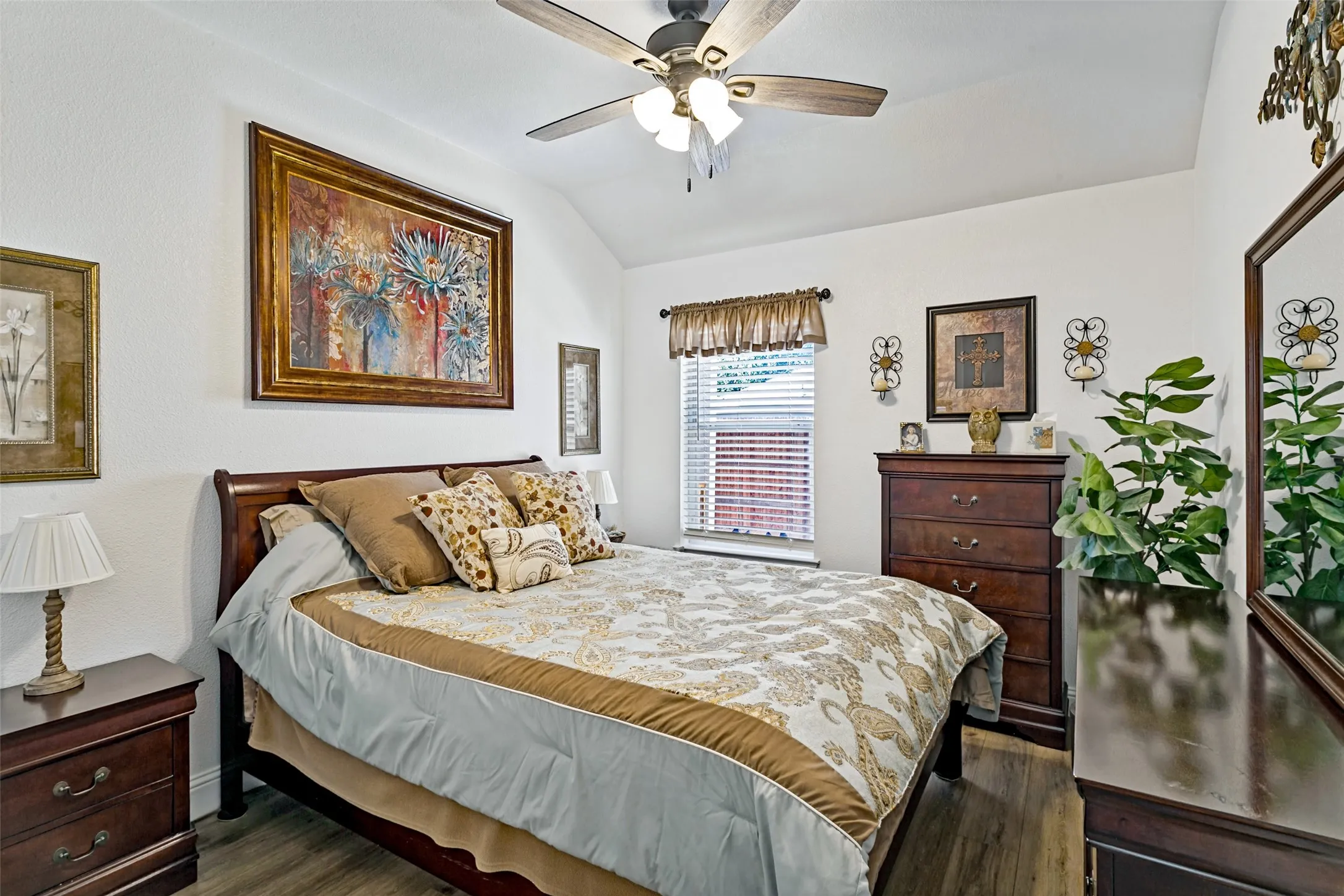 Vaulted ceiling, wood-finish flooring, ceiling fan with integrated lighting, window with blinds