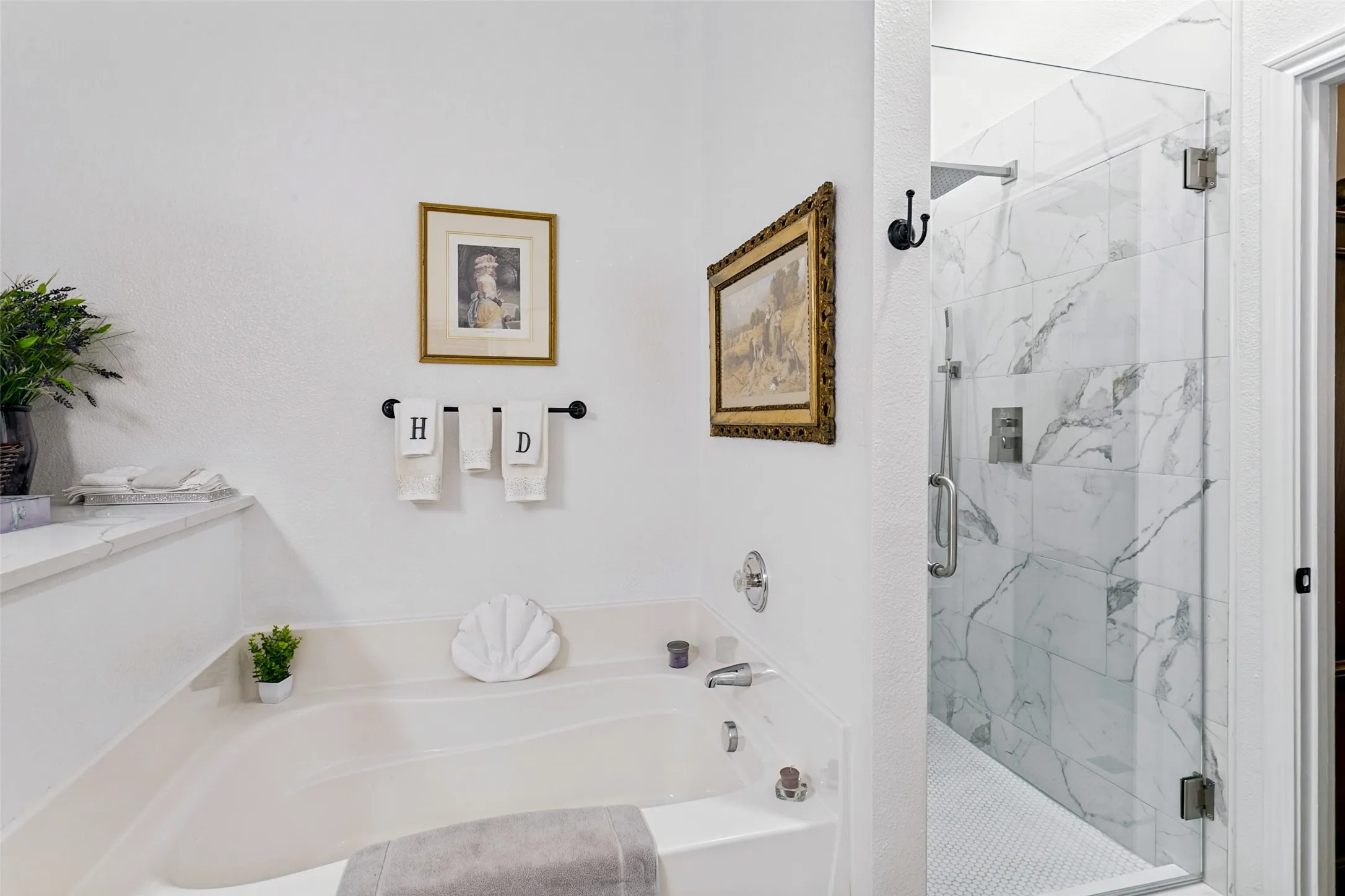 Built-in soaking tub with deck, glass-enclosed shower with tiled walls, and polished chrome fixtures