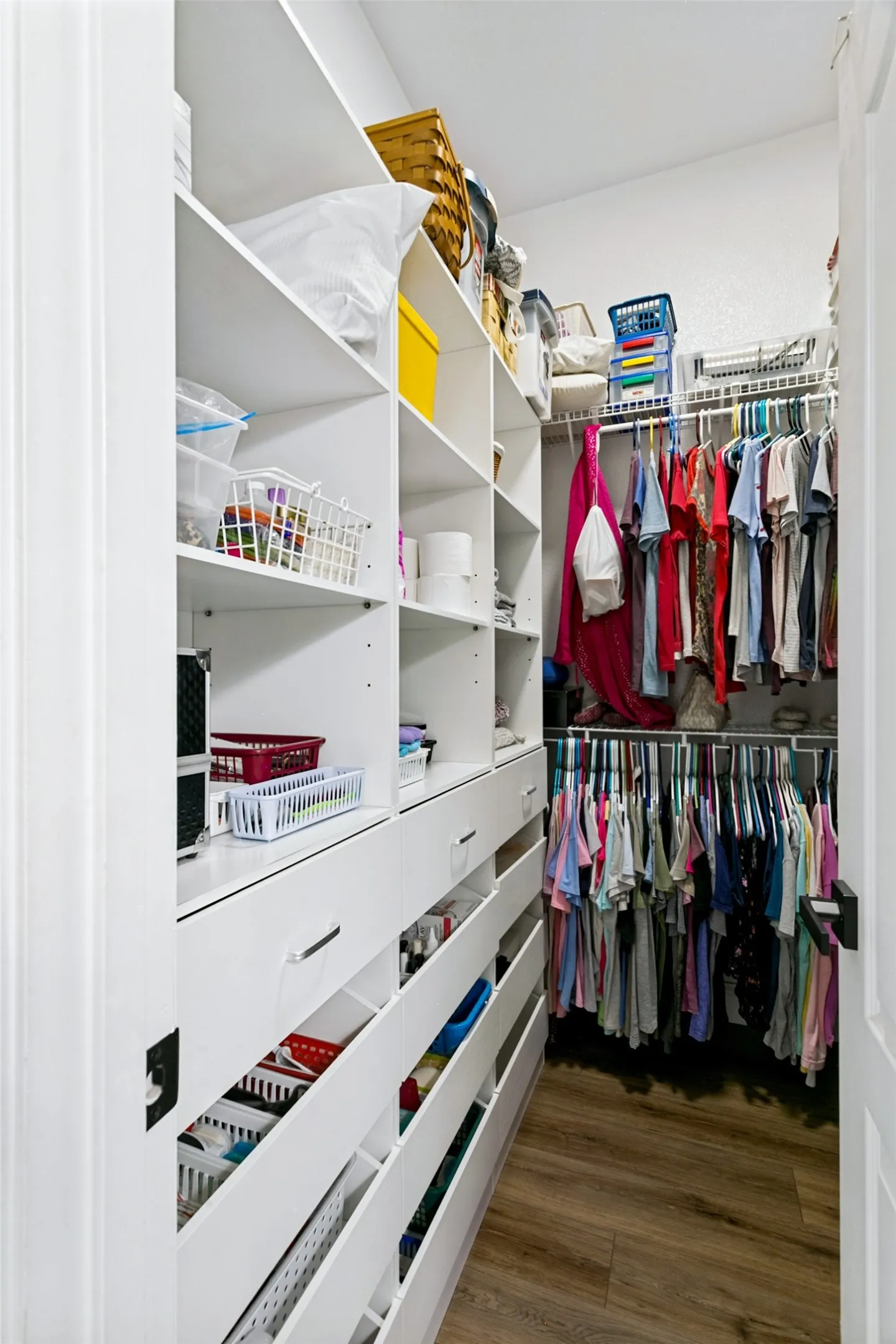 Custom closet system featuring built-in shelving, multiple drawers, and hanging rods