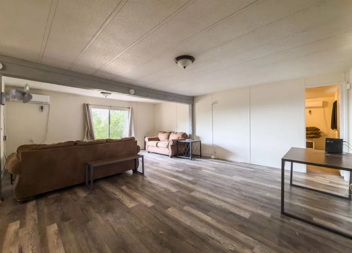 Spacious interior with wood-finish flooring, white walls, and a sliding glass door