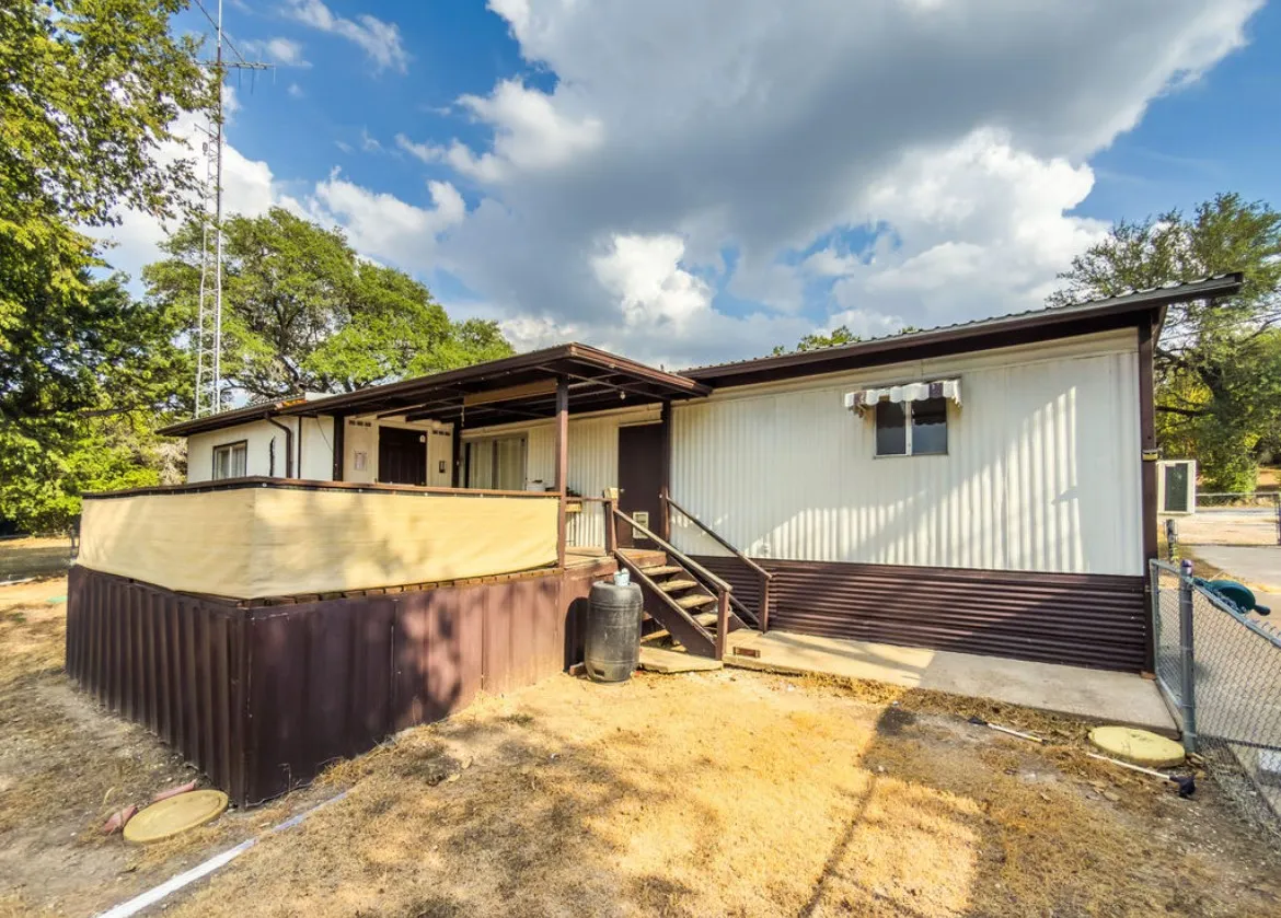 Exterior featuring siding with a contrasting base, a covered entry porch, an additional exterior deck, and a metal roof
