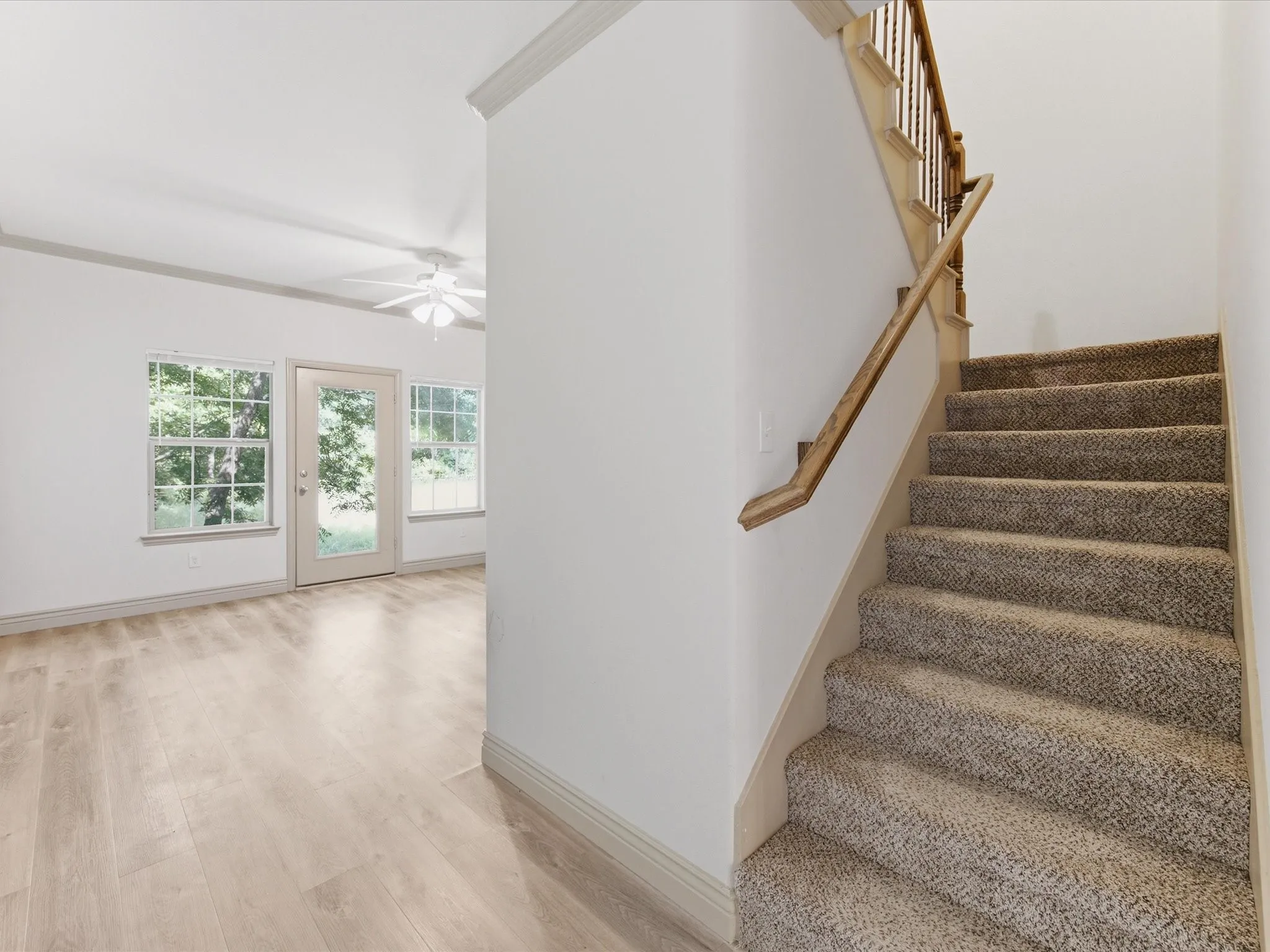 Carpeted staircase with wood banister