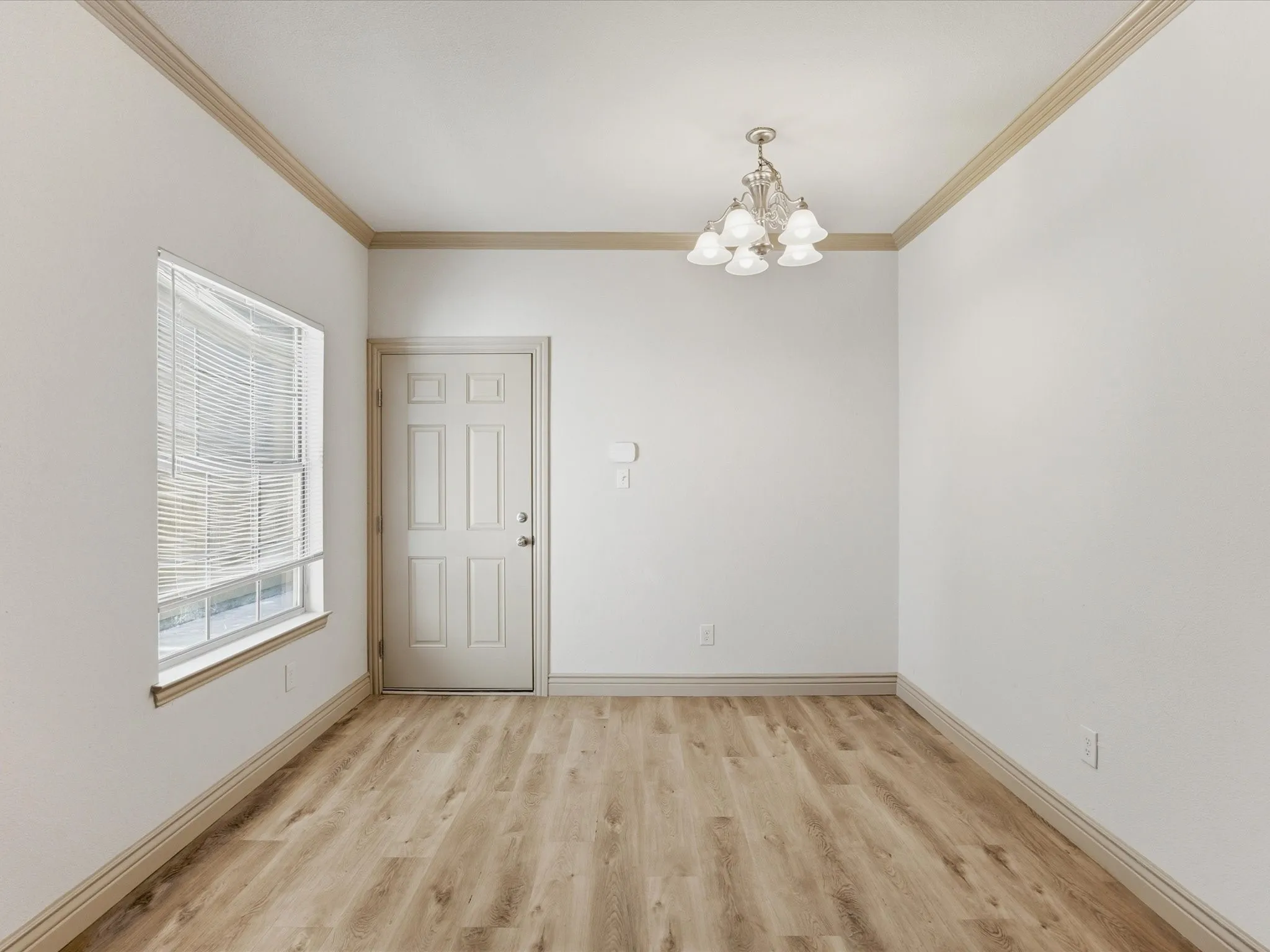 Wood-finish flooring, white walls, and crown molding