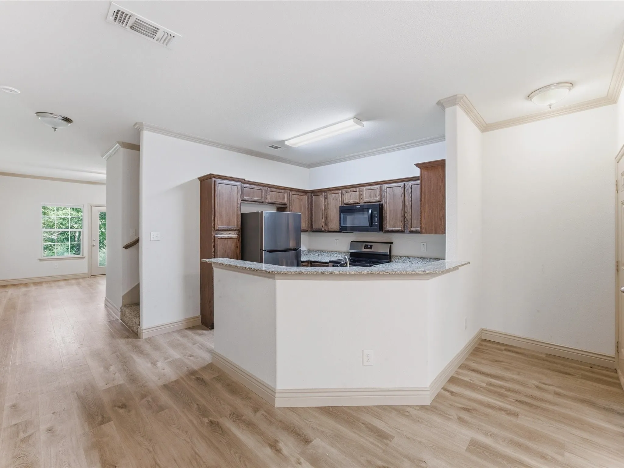 Kitchen featuring dark wood cabinetry, stainless steel appliances, and a light-colored countertop
