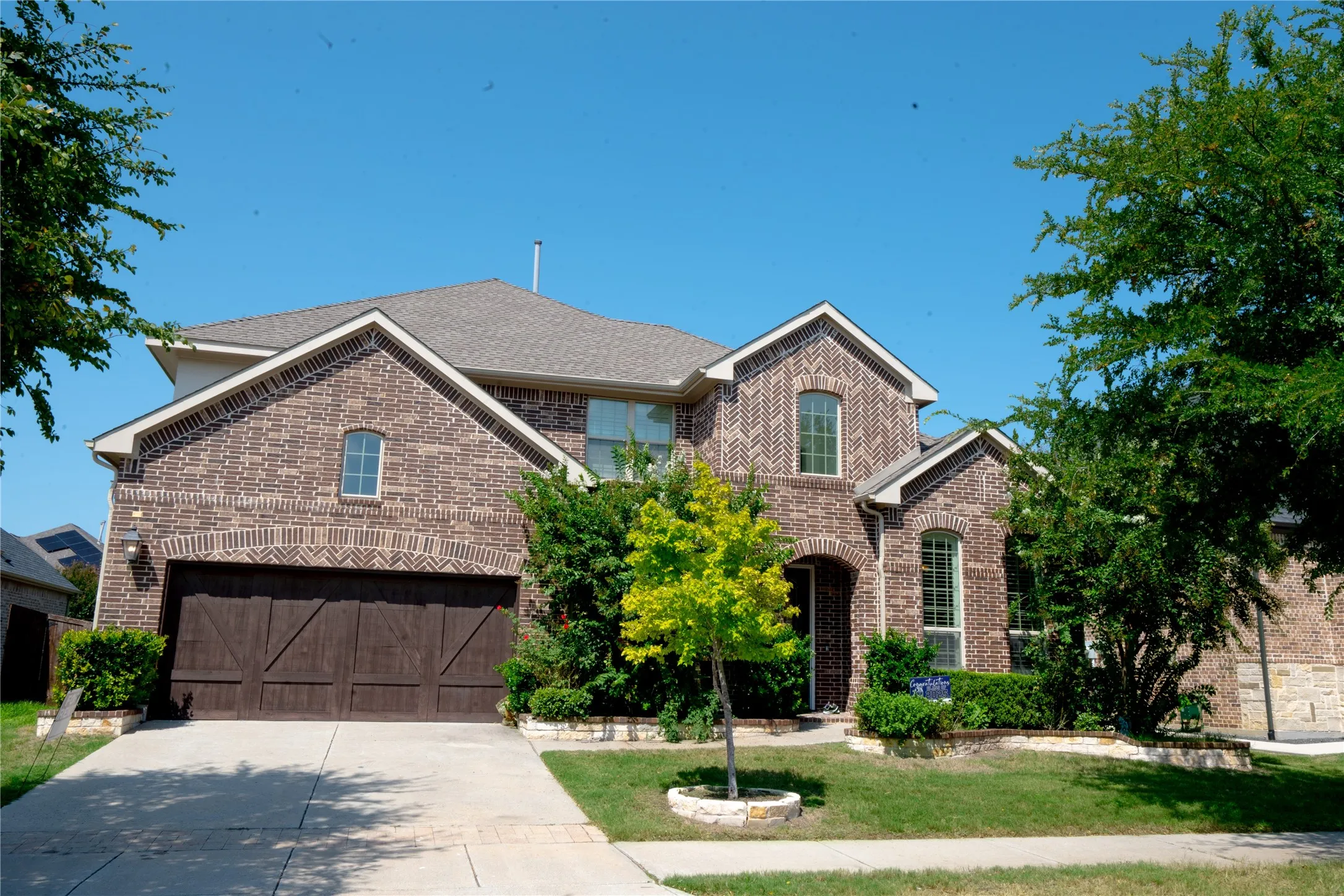 Brick exterior with stone accents, arched windows, and a multi-gabled roofline