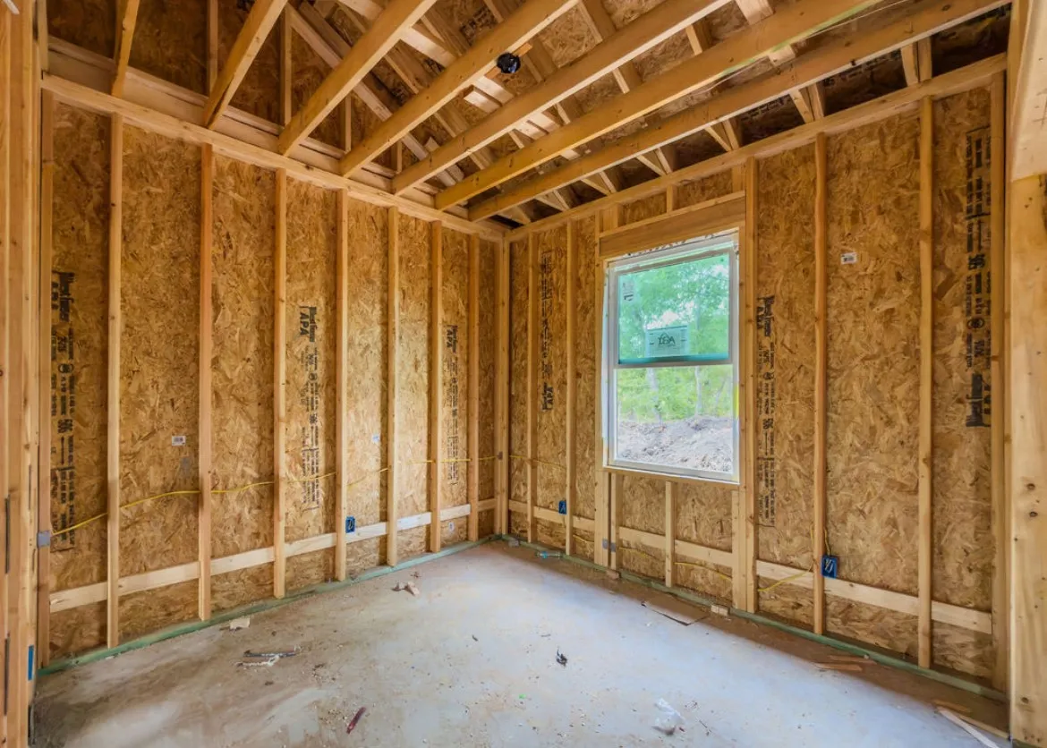 Unfinished interior framing with exposed ceiling joists, wall studs, and subfloor