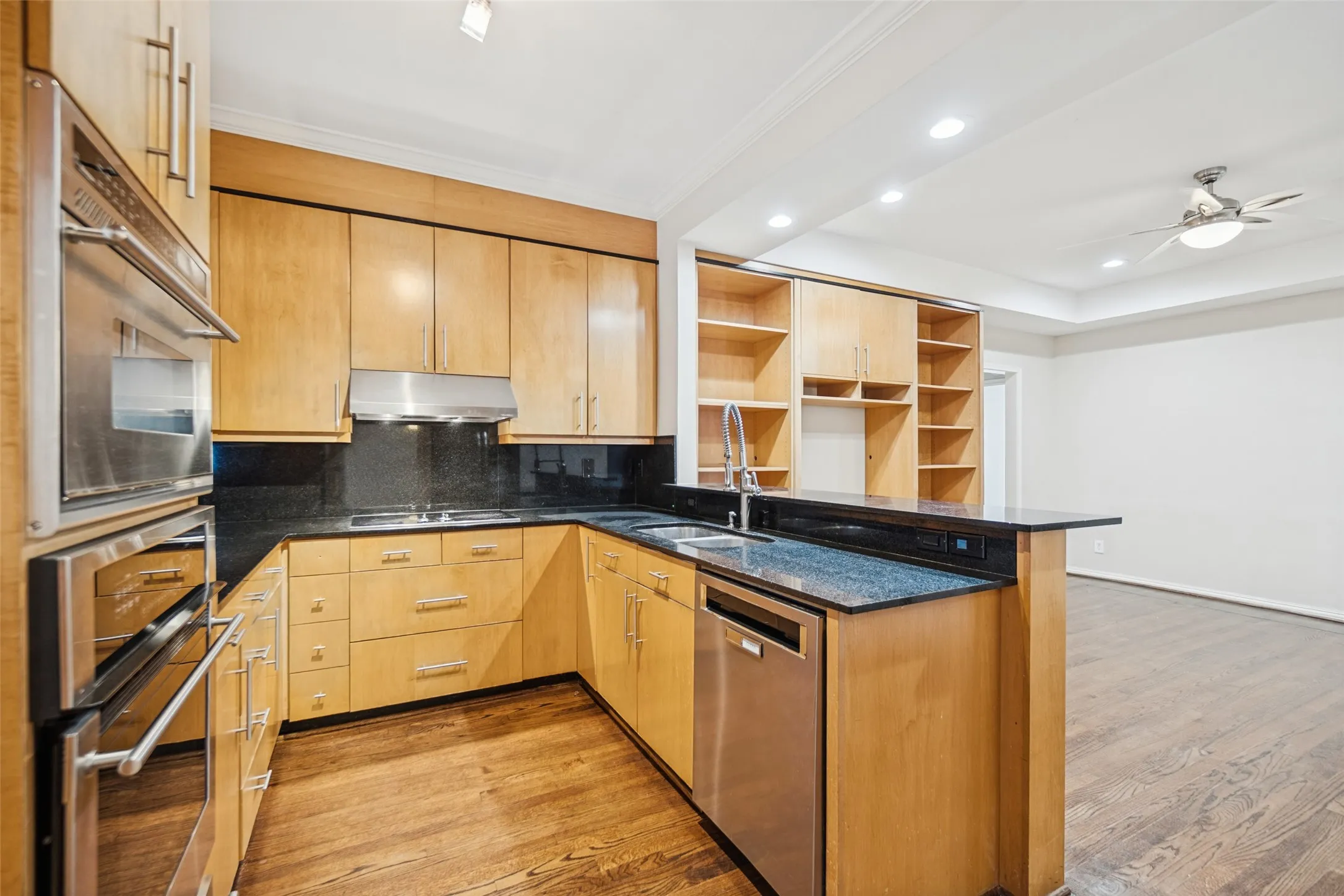 Wood-finish flooring, recessed lighting, and a tray ceiling