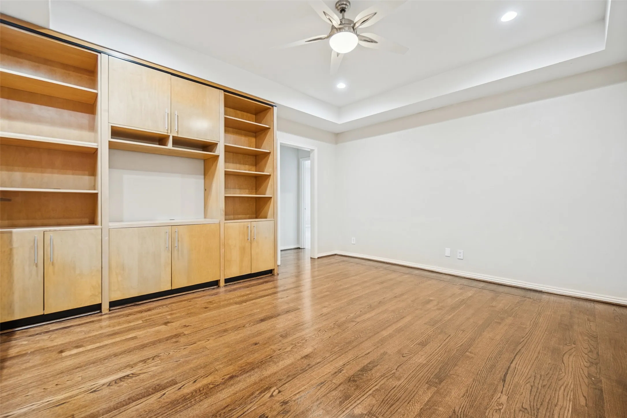 Recessed lighting, wood-finish flooring, ceiling fan, tray ceiling, built-in cabinetry