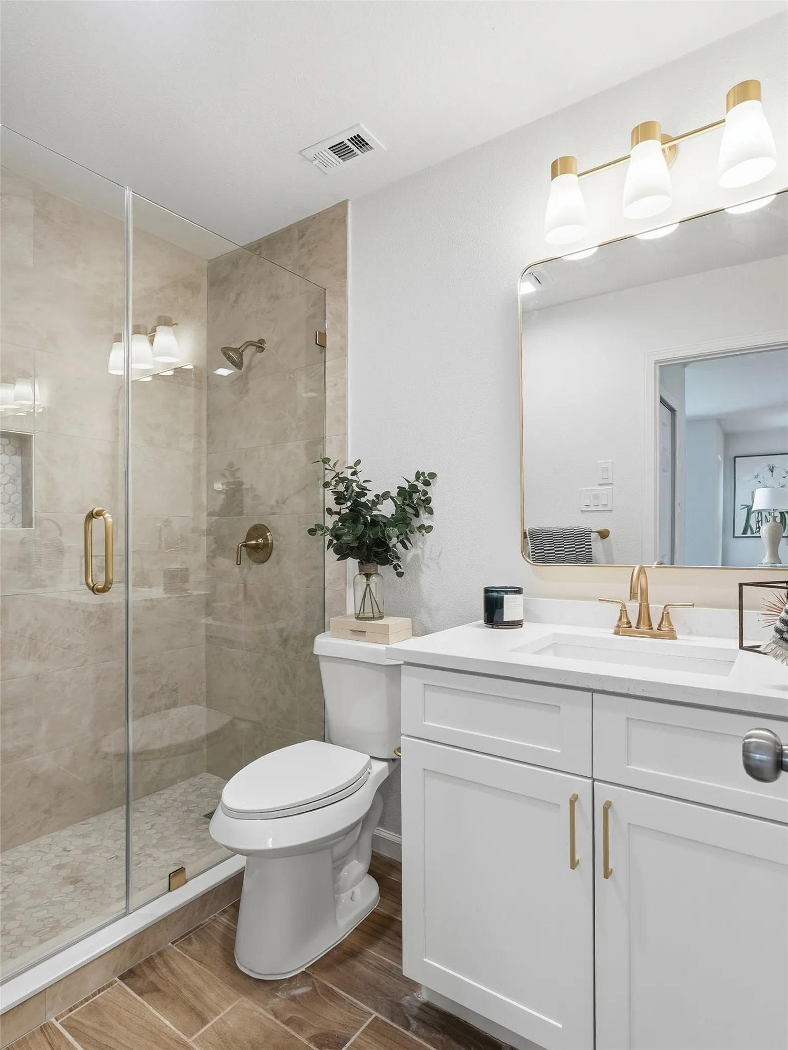 Walk-in shower with clear glass enclosure and light-toned tile surround