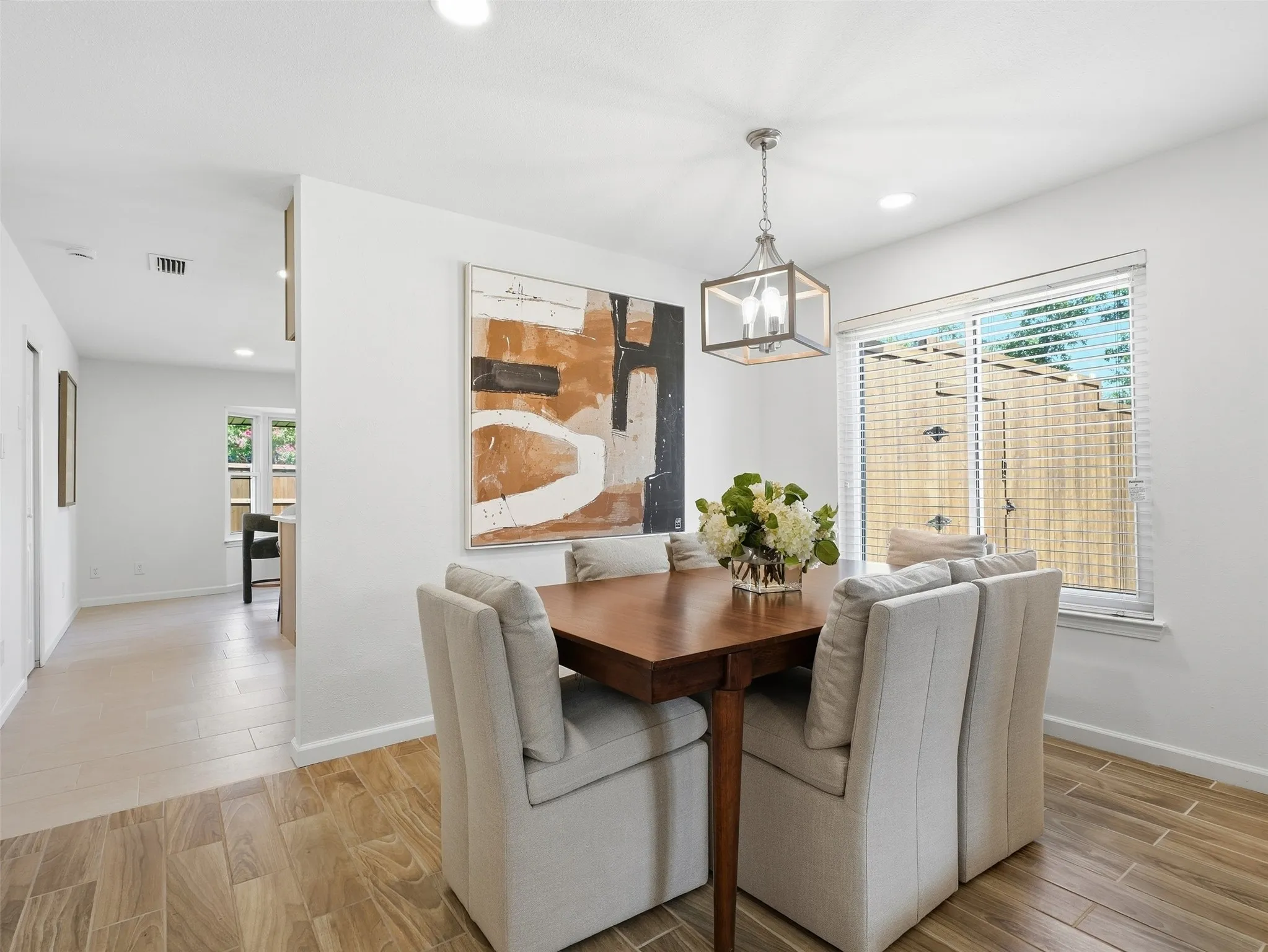 Wood-finish flooring, recessed lighting, and a contemporary chandelier