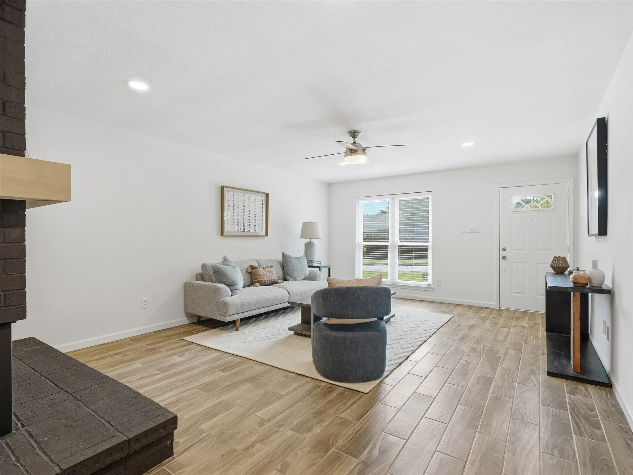 Wood-finish tile flooring throughout, white walls, and recessed lighting