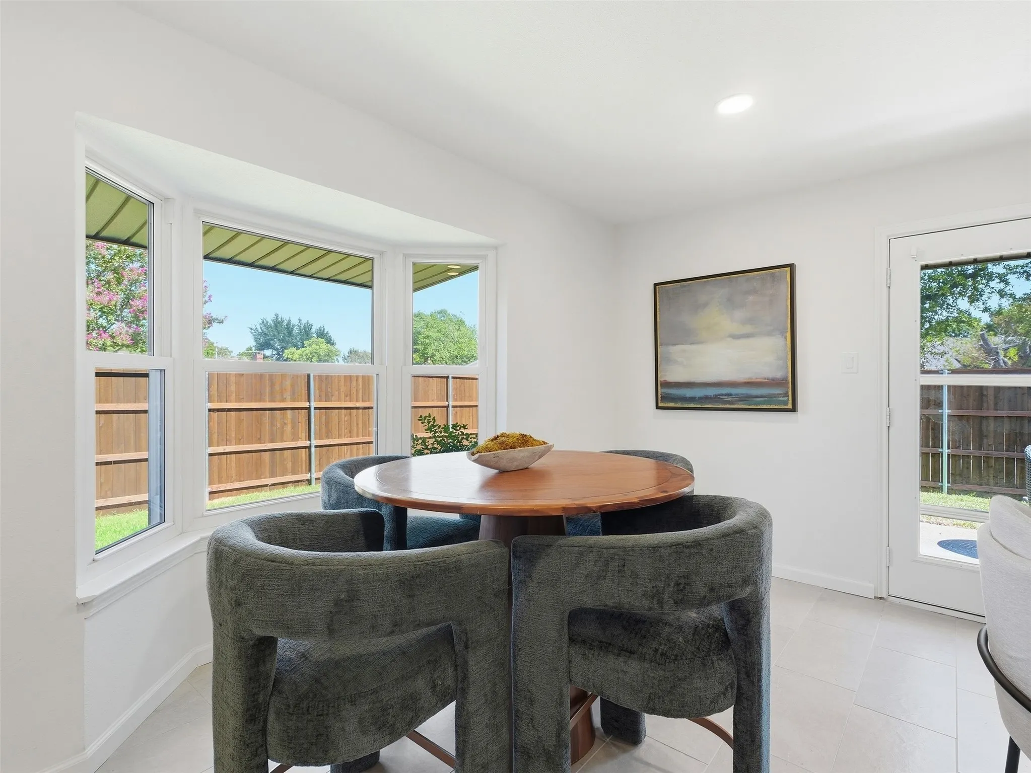 Recessed lighting, bay window, white walls, light-toned flooring, and a glass-paneled exterior door