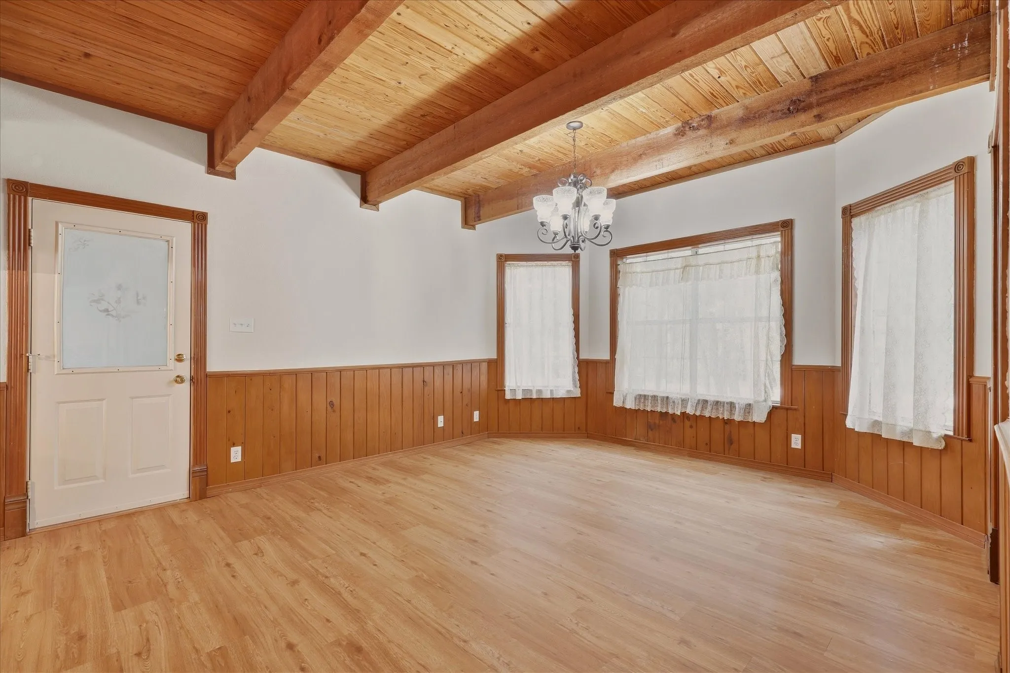 Dining area with windows facing front of property and door to garage on the left.