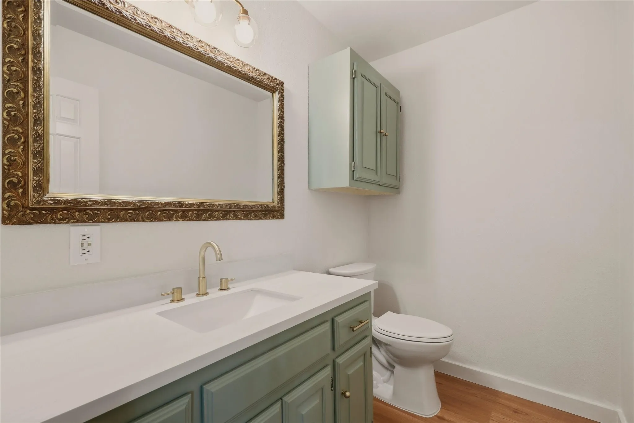 Downstairs half-bath with new light fixtures, mirror, vanity, and hardware.