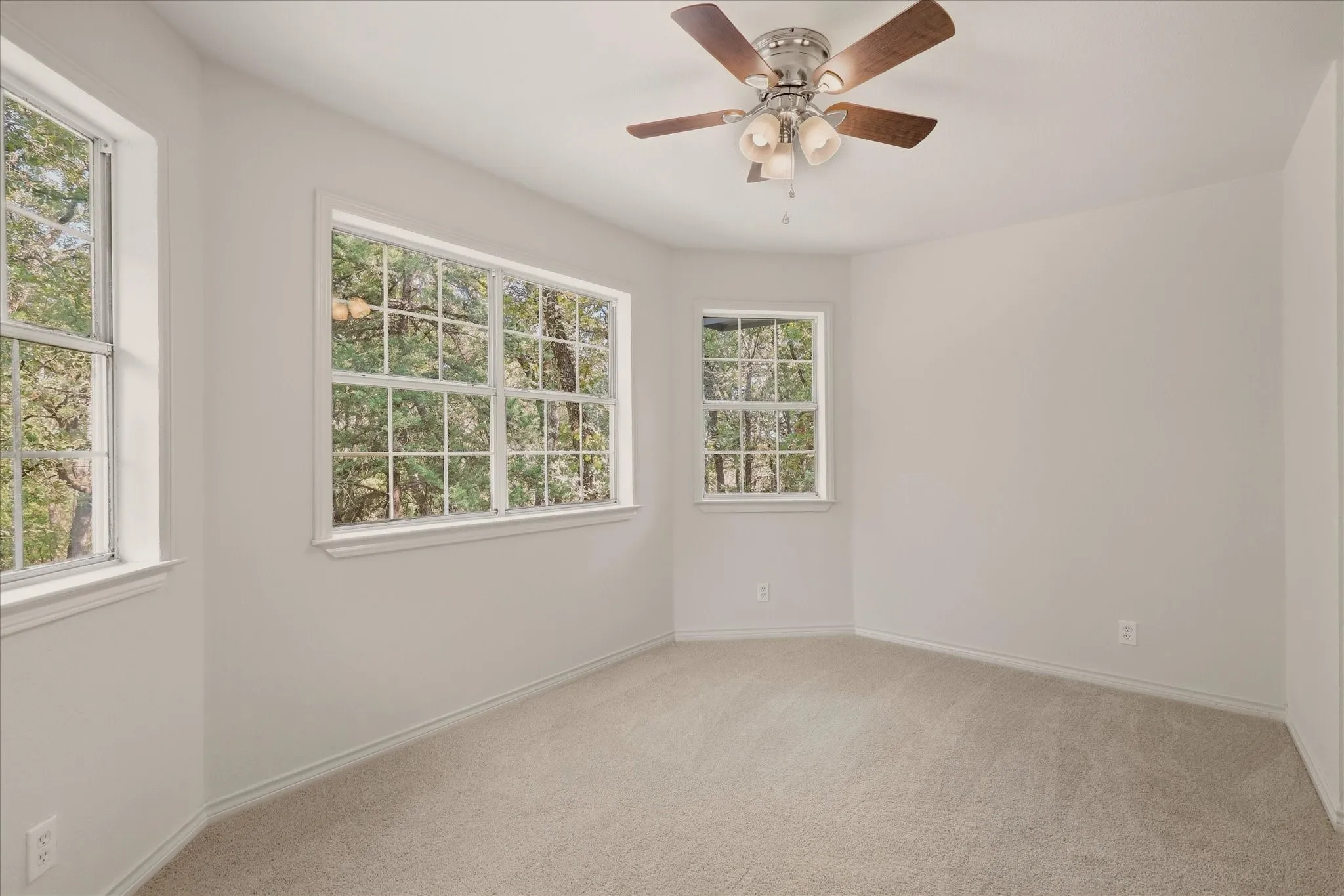 Second upstairs bedroom, featuring a view of the trees out front.