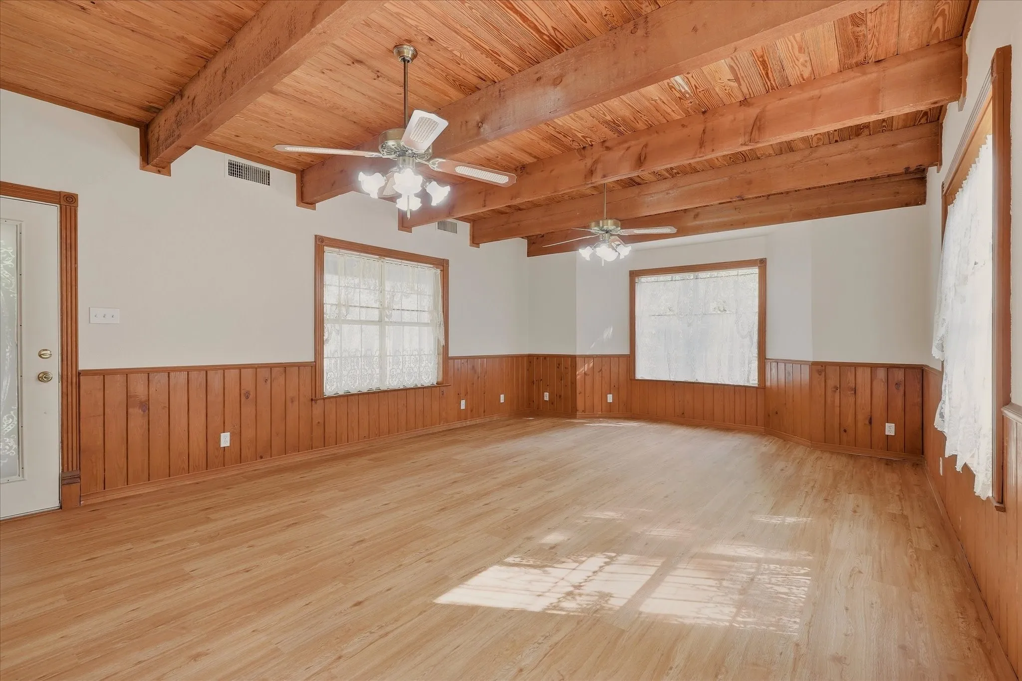 Living room with front door on the left and lots of windows for beautiful natural light to filter through.