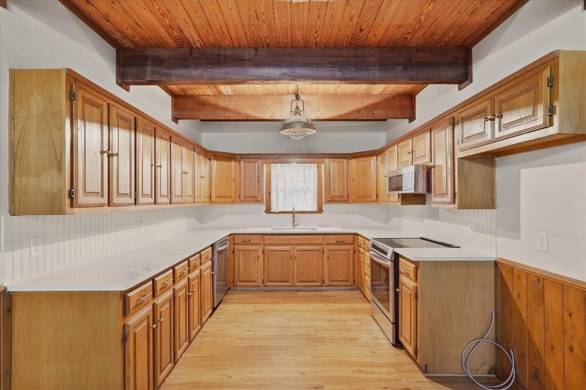 Many charming, original features were kept in tact, such as the wooden ceiling and cabinets. A beautifully crafted antique light fixture also hangs above the center of the kitchen - pictures don't do it justice!