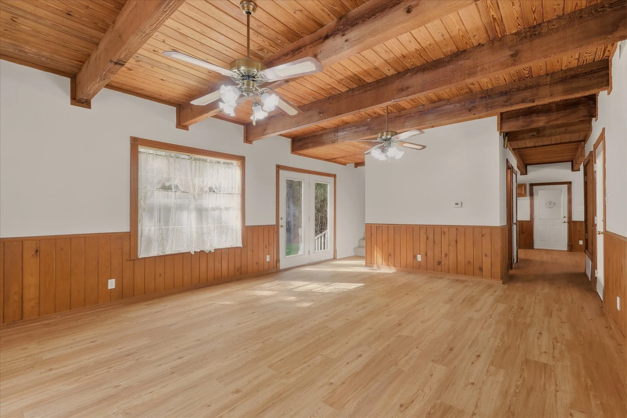 Living room with beautiful light, backyard access to the left, and the staircase just around the corner.