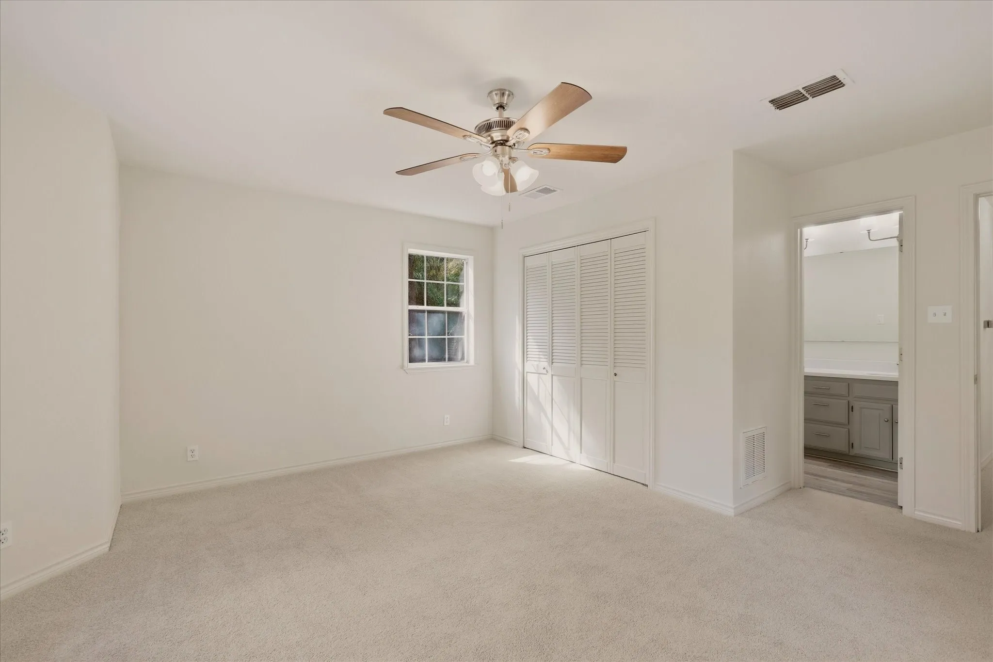 Primary bedroom with ensuite bathroom and double door closet.
