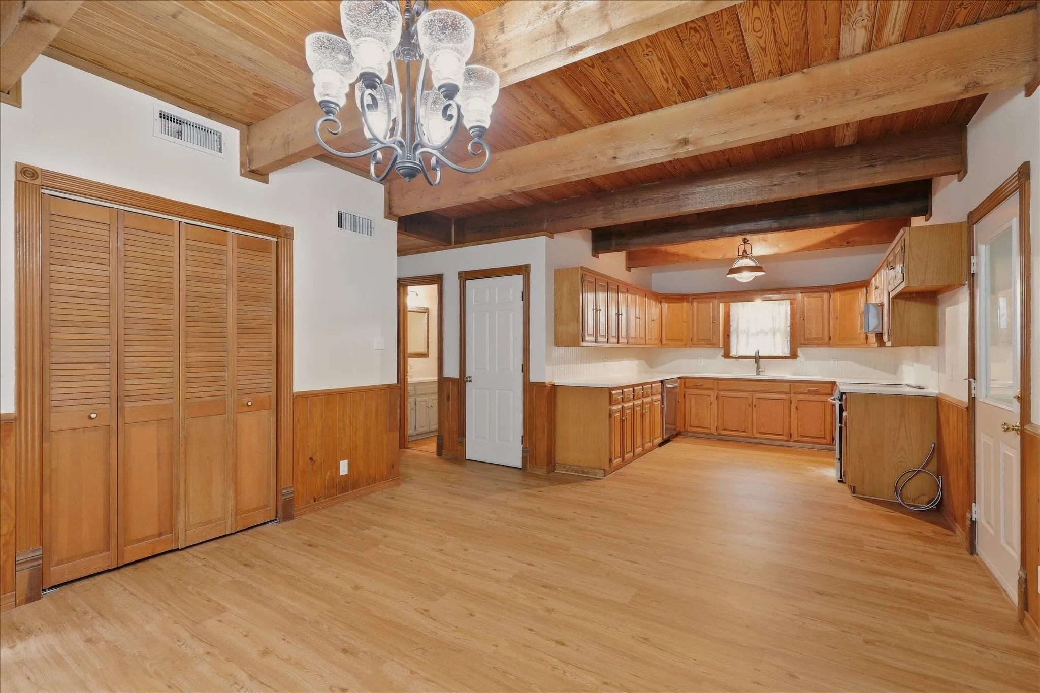 Dining area and kitchen, with laundry room to the left and storage closet straight ahead. Garage access to the right.