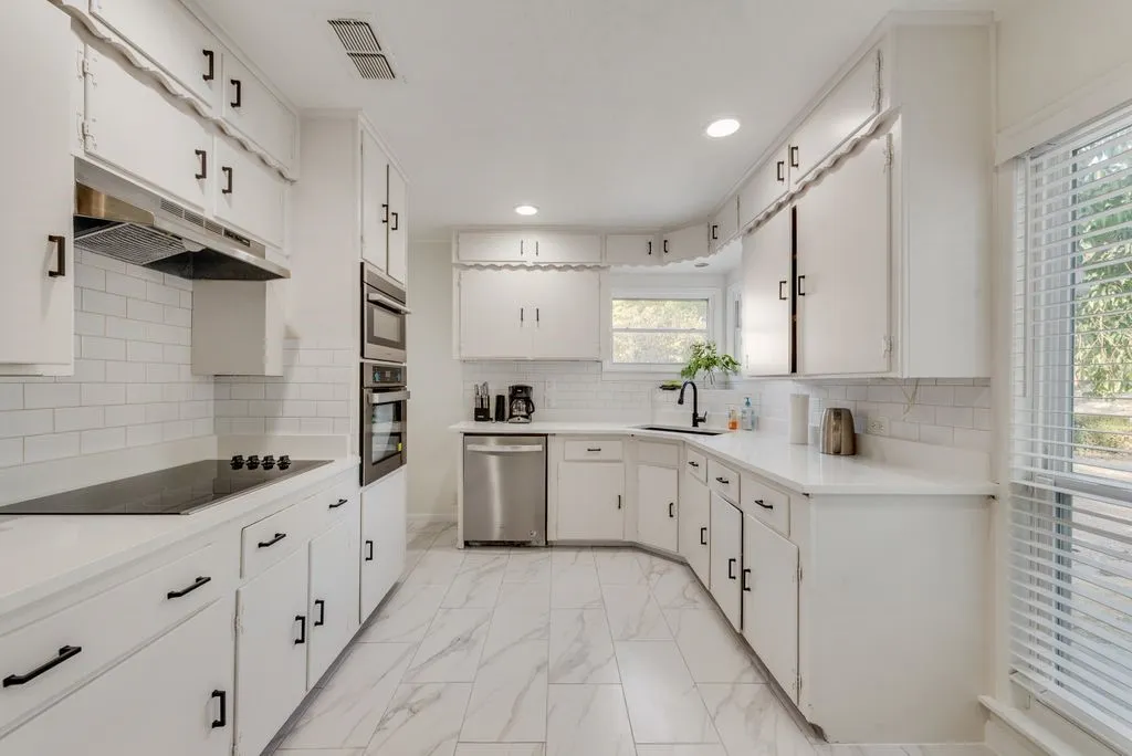 Cook your favorite meals in this bright kitchen with quartz counters, subway tile, and plenty of cabinet space.