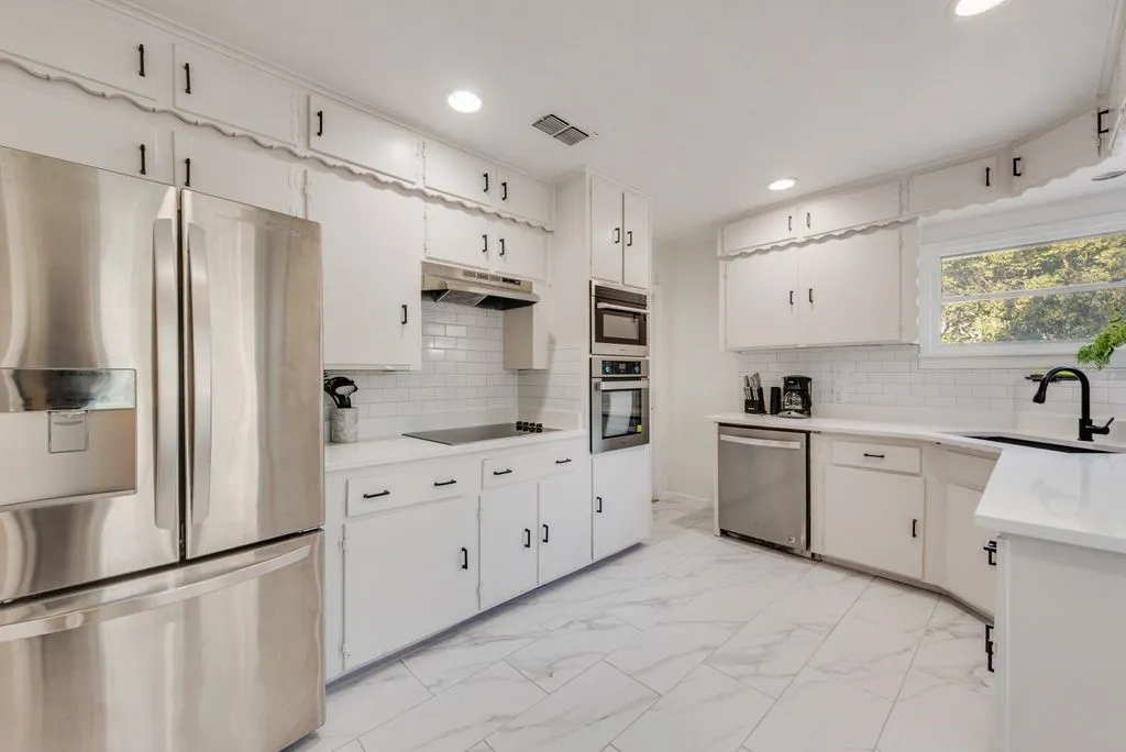 Stainless appliances, double wall ovens, and a sleek cooktop make weeknight dinners a breeze.