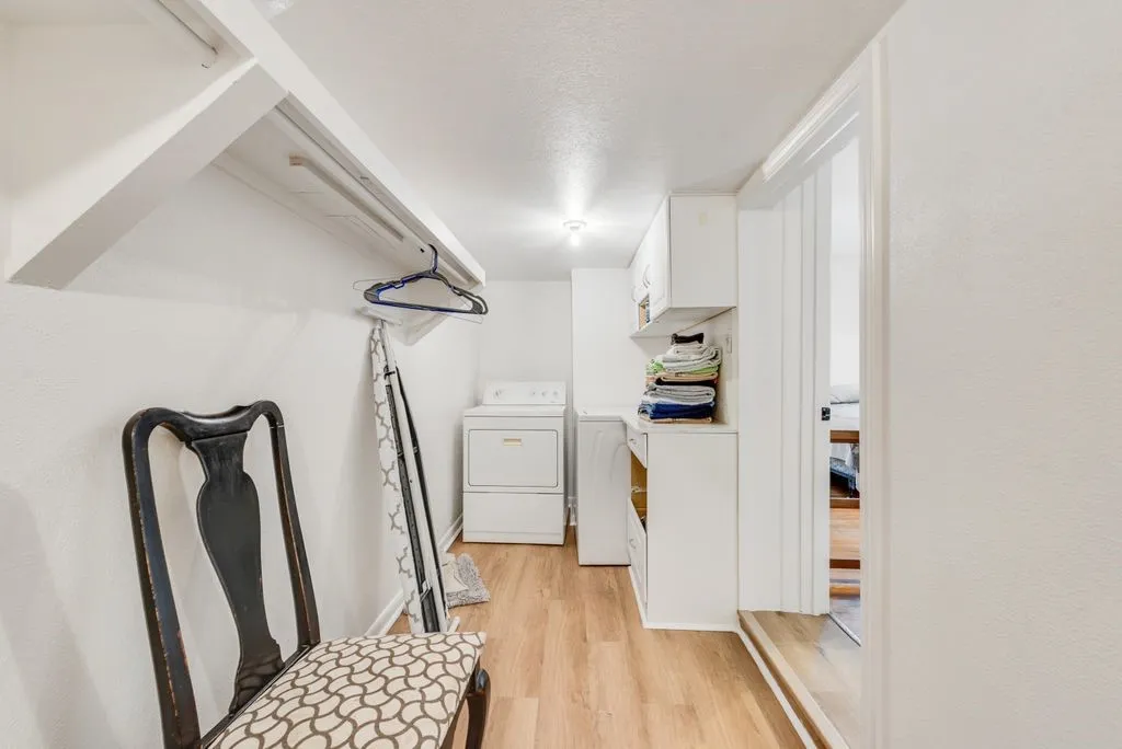 Laundry day made easy, with a washer and dryer tucked away alongside extra shelving and hanging space.