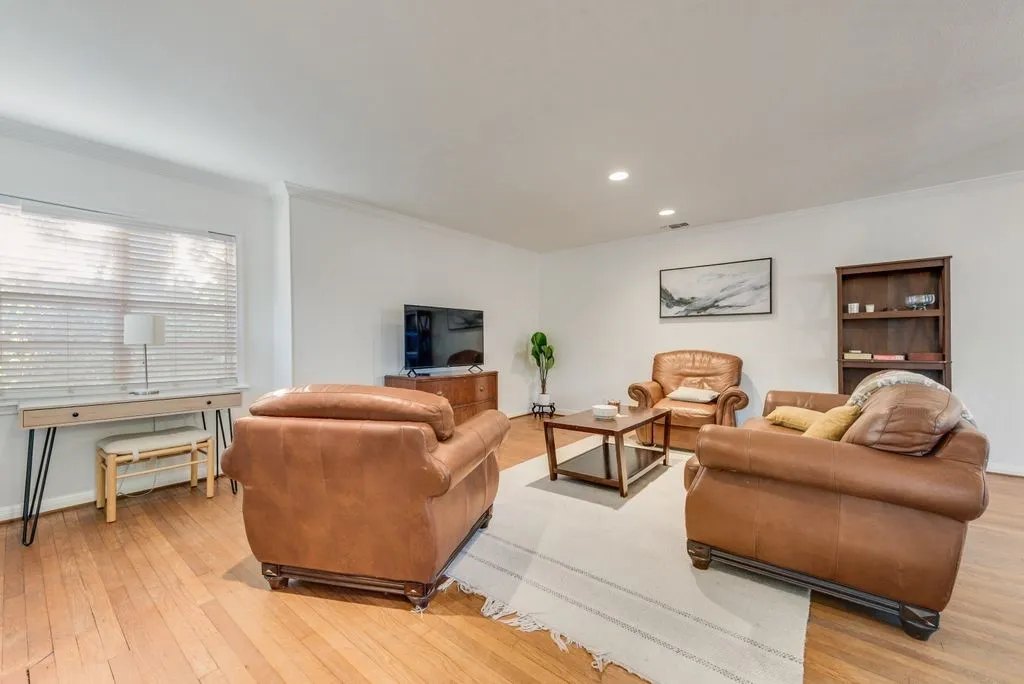 Gather the family for movie night in this spacious living room with original hardwood floors.