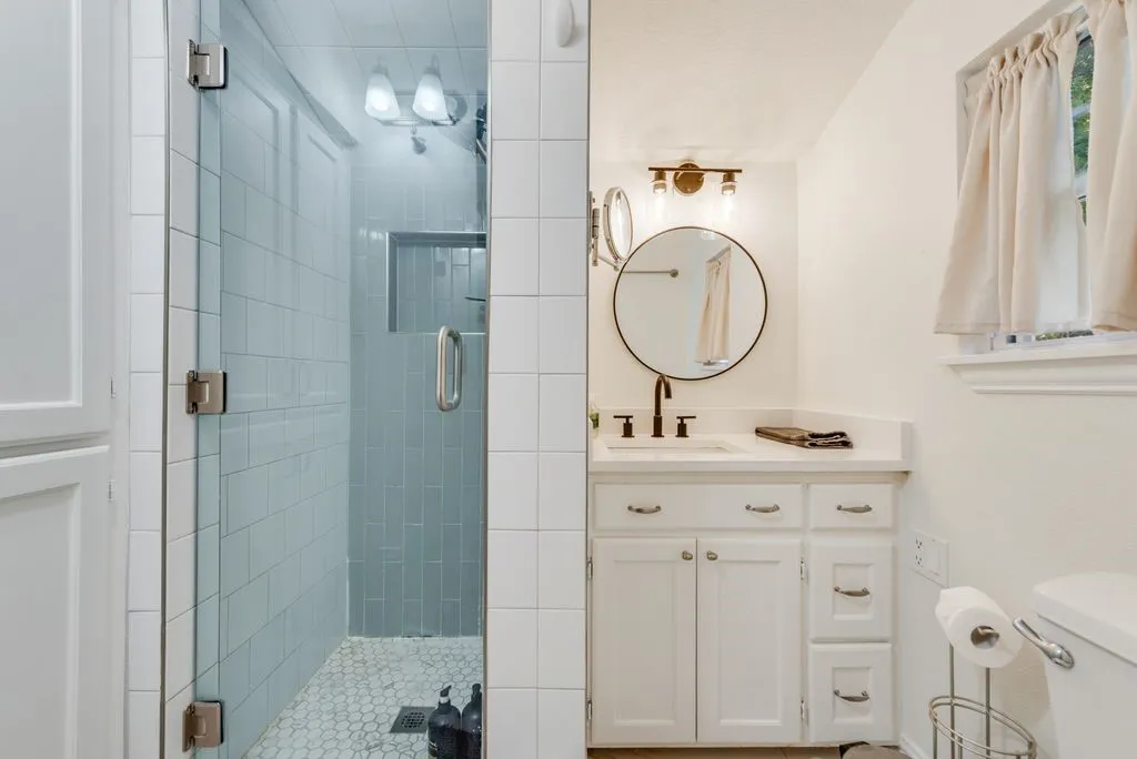 Start your mornings in the glass walk in shower with spa blue tile and a built in niche for all your essentials.