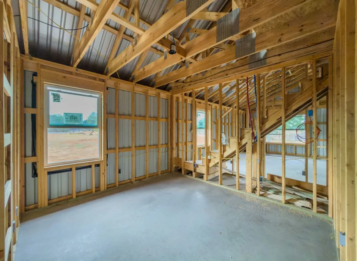 Exposed wood framing, concrete flooring, and metal wall sheathing