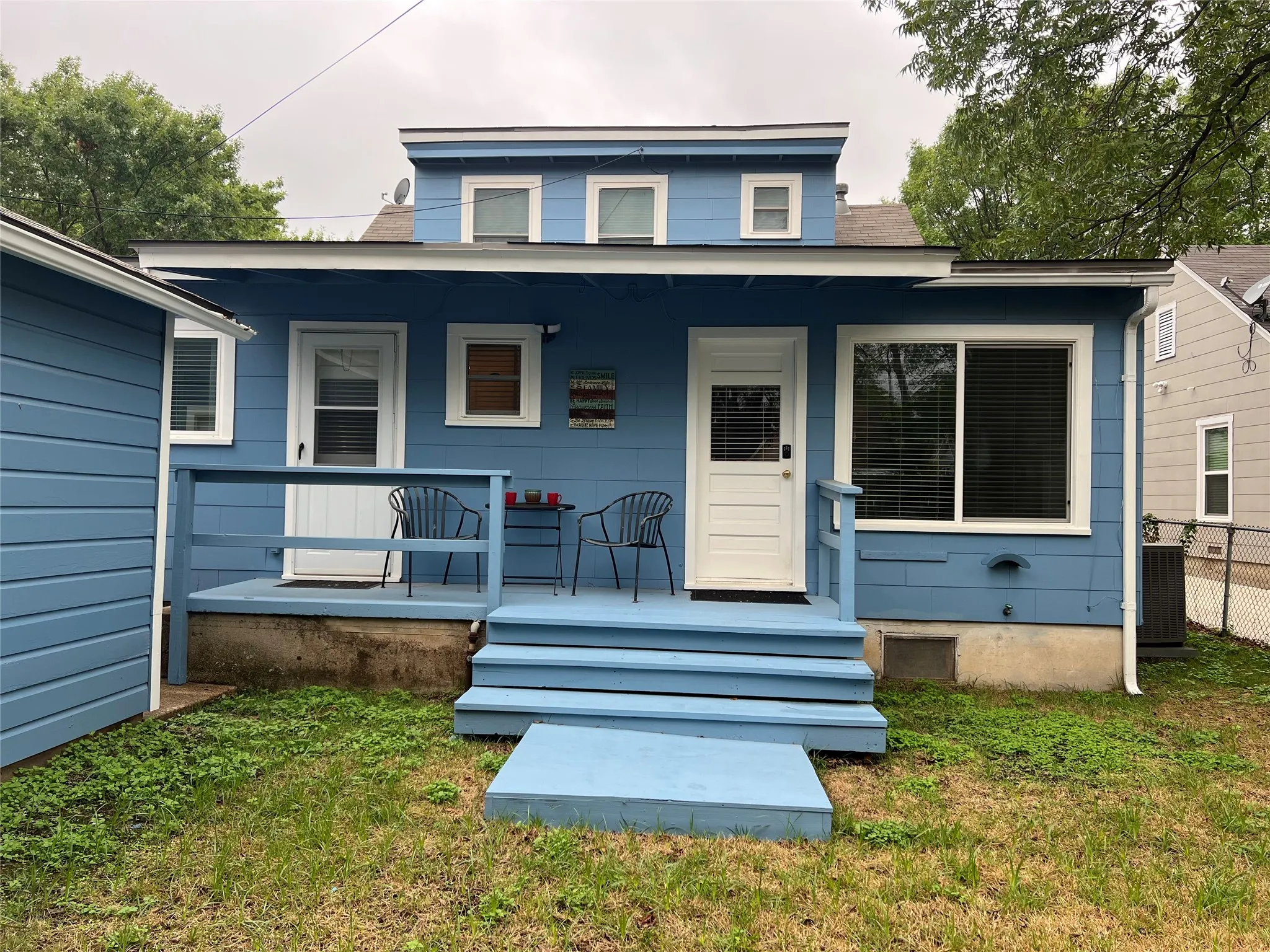 View of back of home with a porch and yard.
