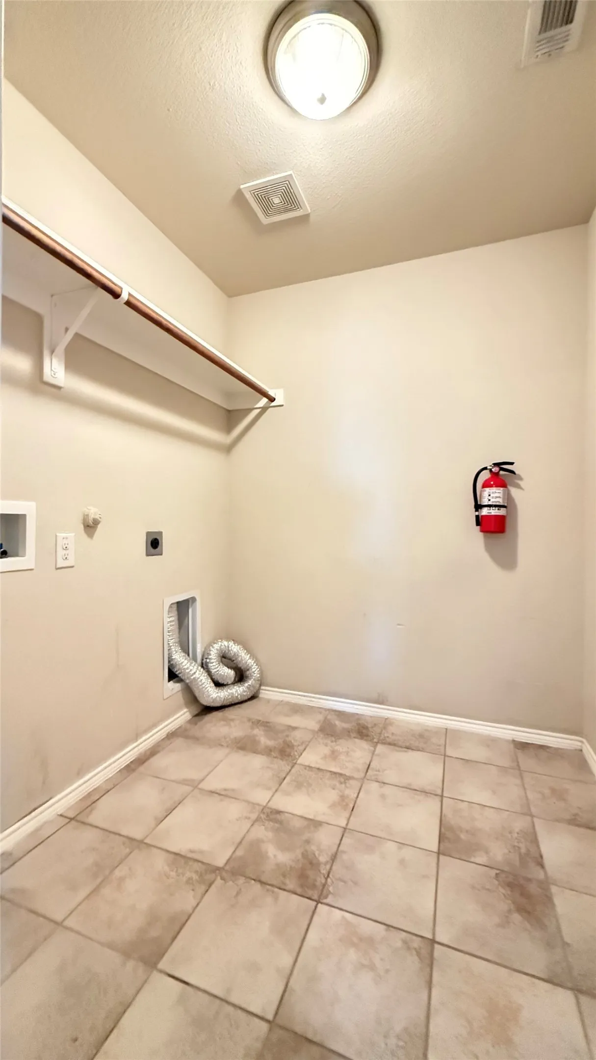 Washroom featuring hookup for an electric dryer, hookup for a washing machine, tile patterned floors, baseboards, and hookup for a gas dryer