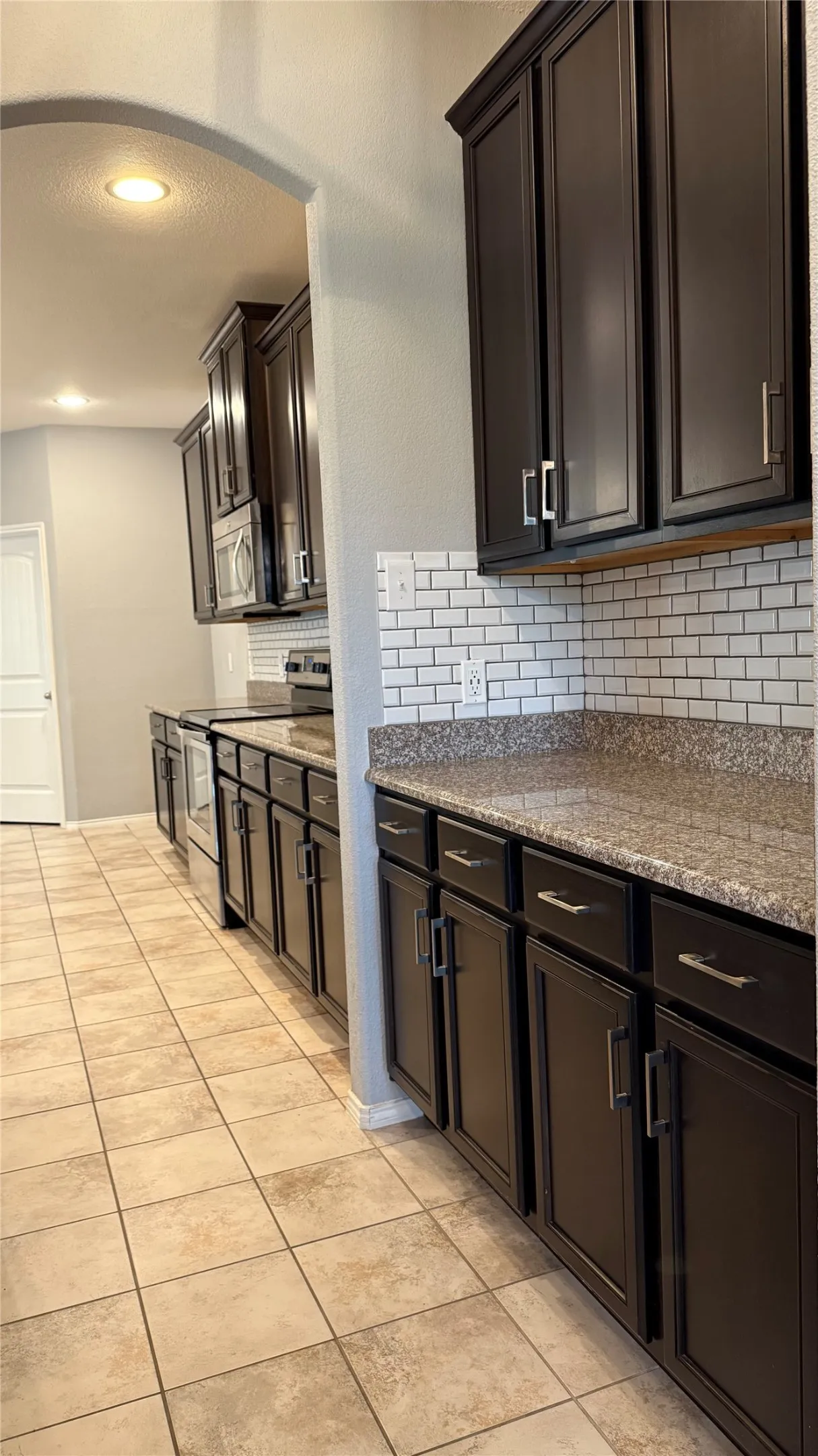 Kitchen featuring appliances with stainless steel finishes, backsplash, light tile patterned floors, and recessed lighting