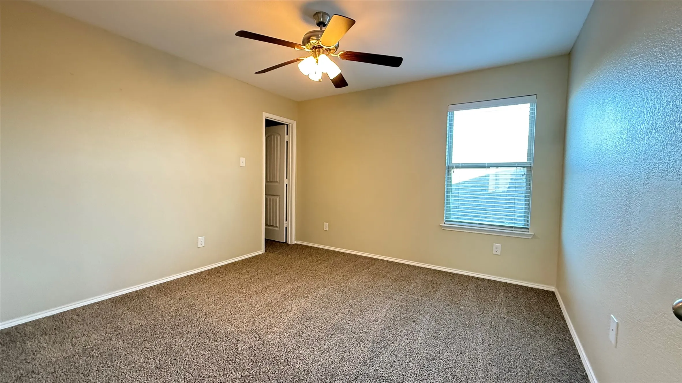 Unfurnished room with dark carpet, ceiling fan, and baseboards