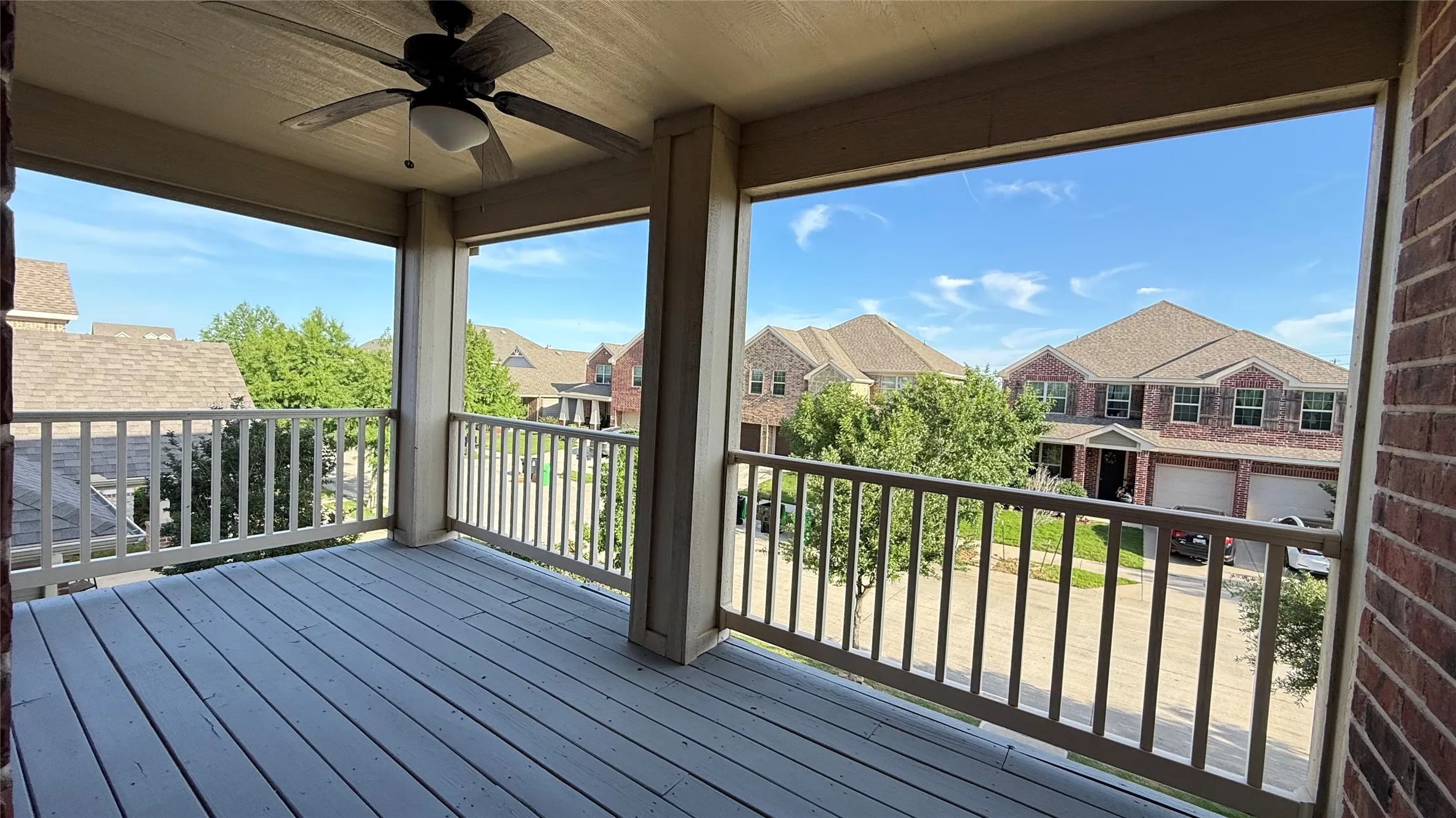 Wooden deck with a residential view and a ceiling fan