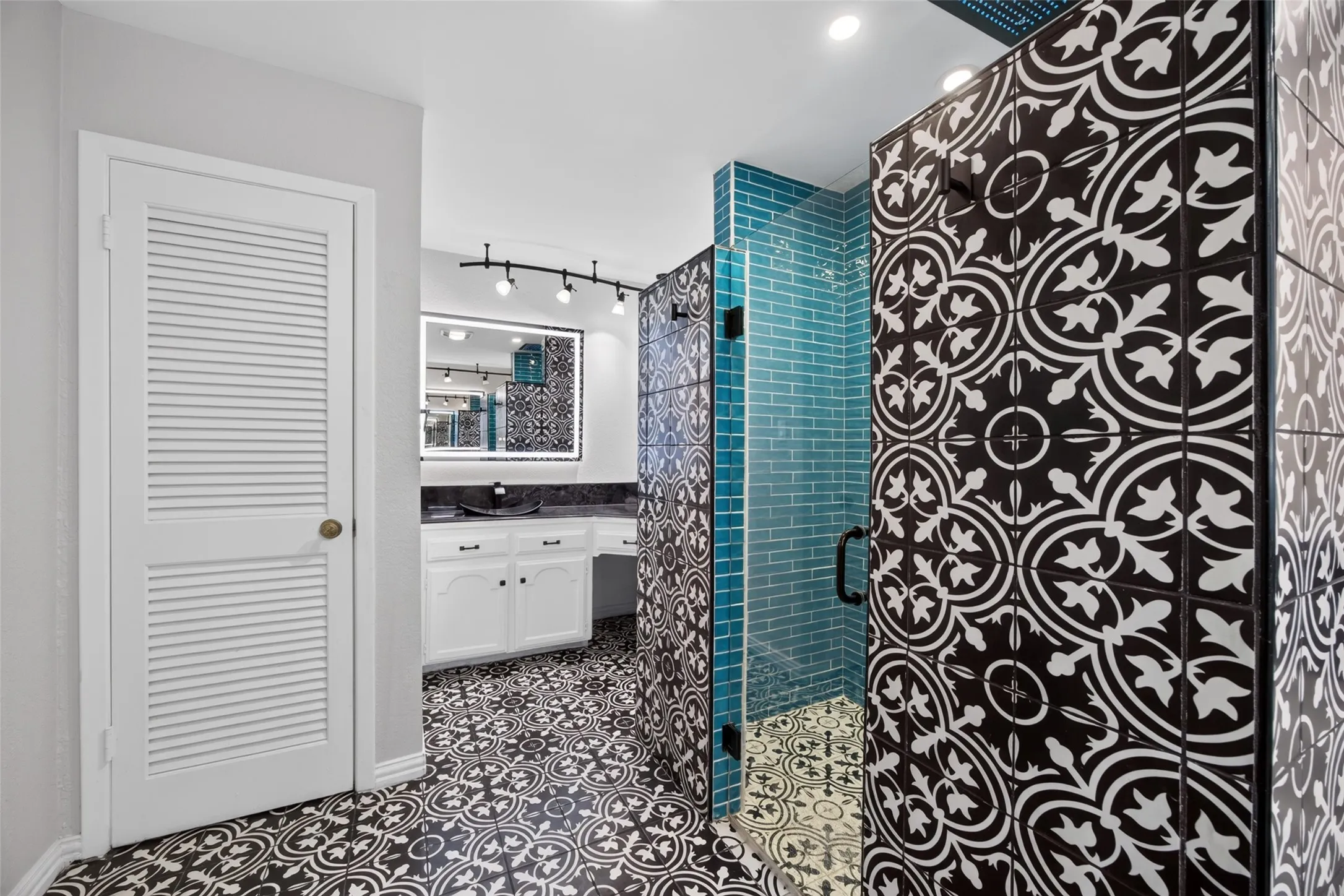 The primary bathroom is simply spectacular! Cool tile, rain showerhead in the ceiling, separate vanities with lighted mirrors, and 2 closets