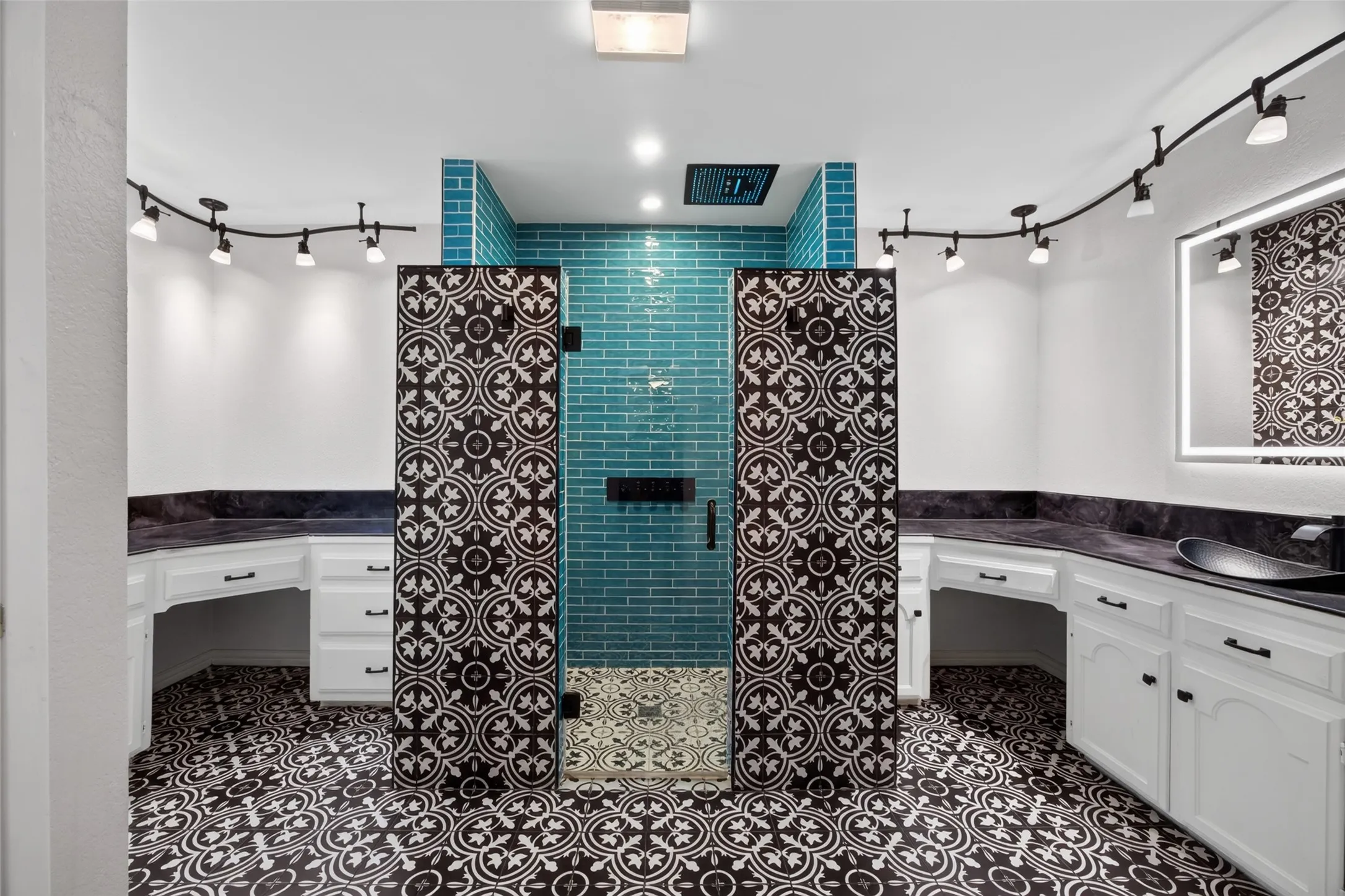 The primary bathroom is simply spectacular! Cool tile, rain showerhead in the ceiling, separate vanities with lighted mirrors, and 2 closets