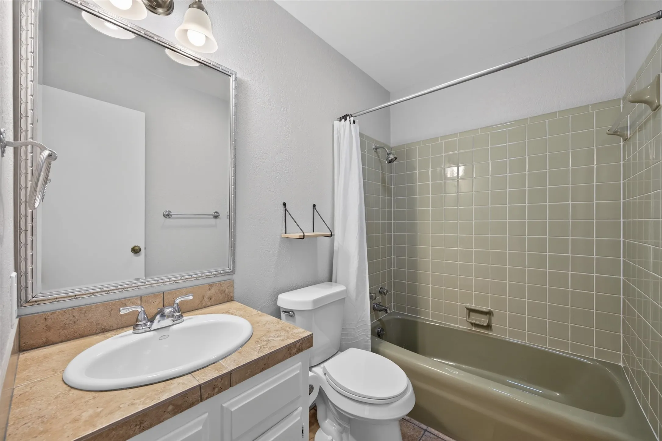 Bathroom between bedrooms 2 & 3 has original retro tile and avacado green tub