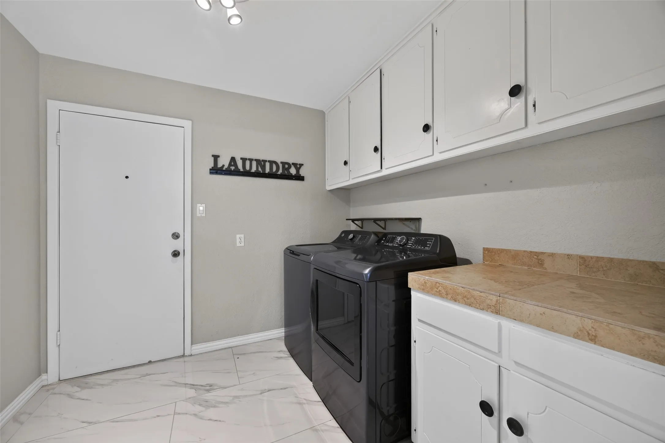 Large laundry room off the kitchen with lots of cabinets